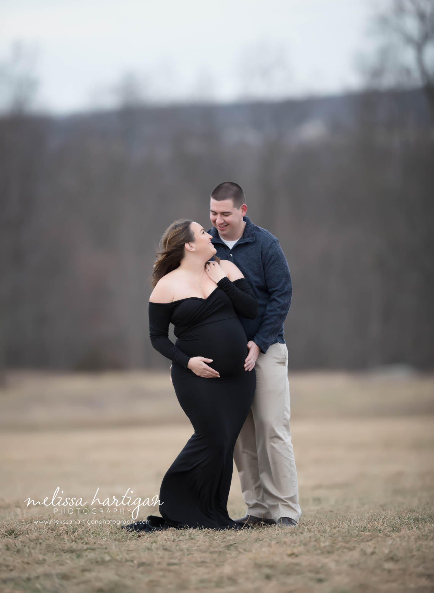 couples maternity photos standing poses with moms hands and dads hands on belly winter maternity pictures with no snow