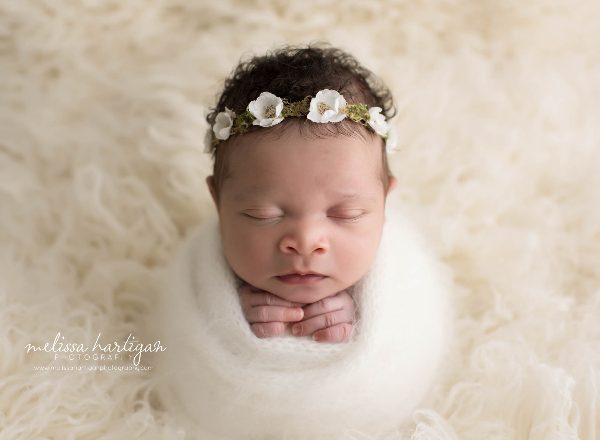 baby girl wrapped potato sack pose in knitted cream colored wrap with cream white flower headband