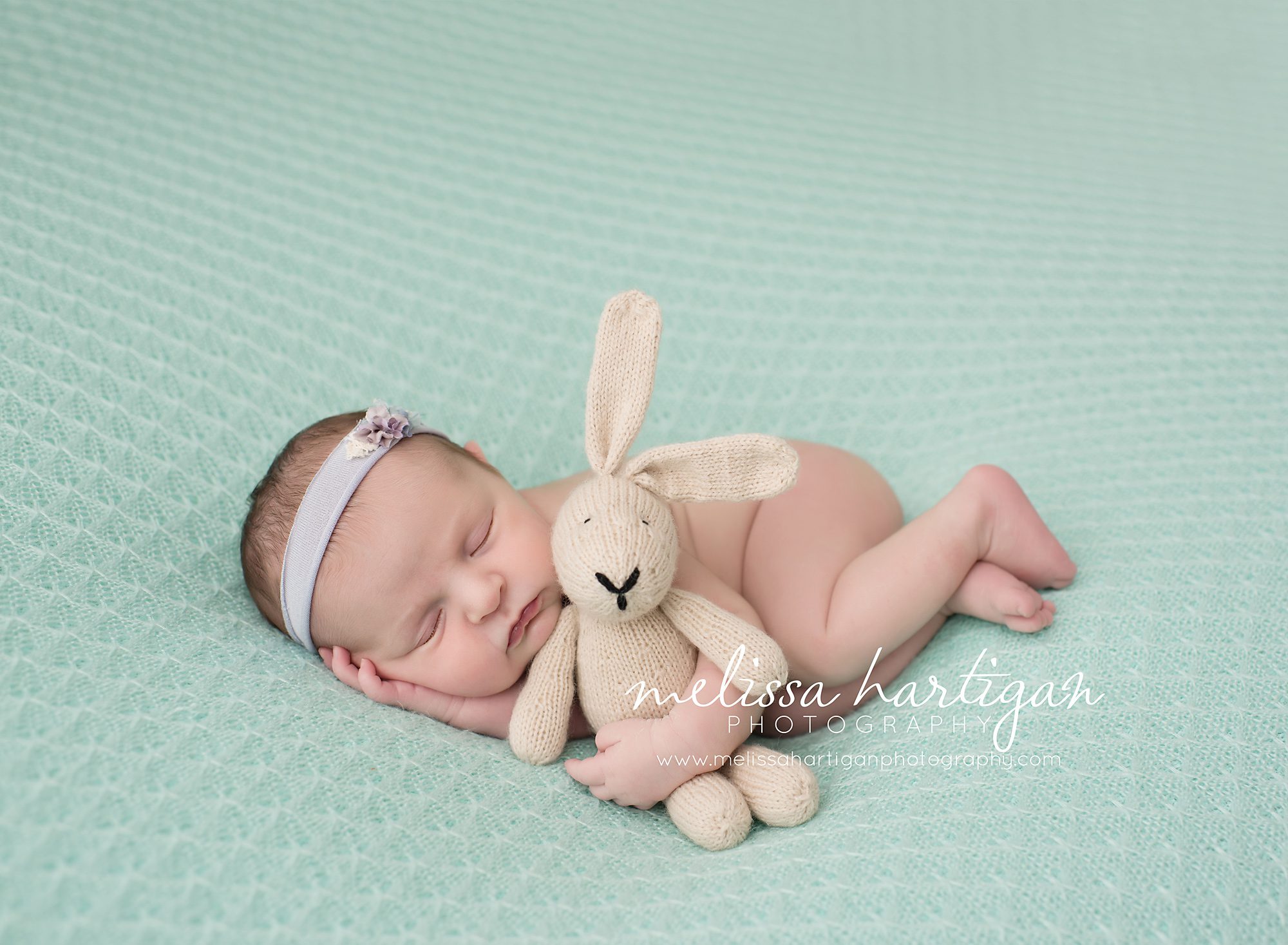 baby girl sleeping o0n side with knitted bunny and light purple colored floral headband CT newborn photographer