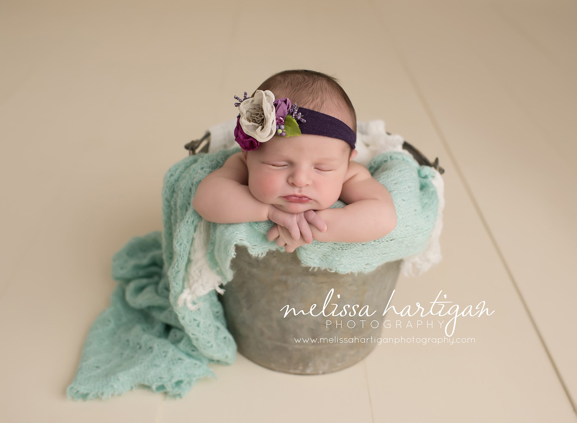 baby girl posed in bucket with cream light mint green and plum colors