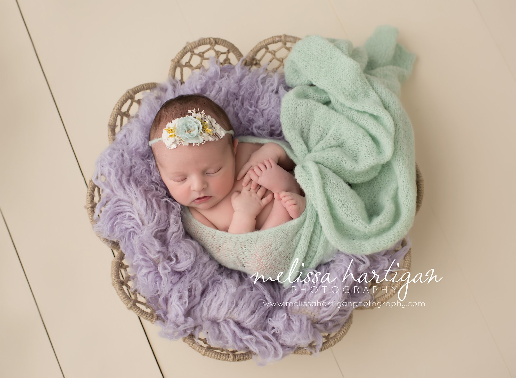 Baby girl posed in bowl with mini and lilac colored flokati