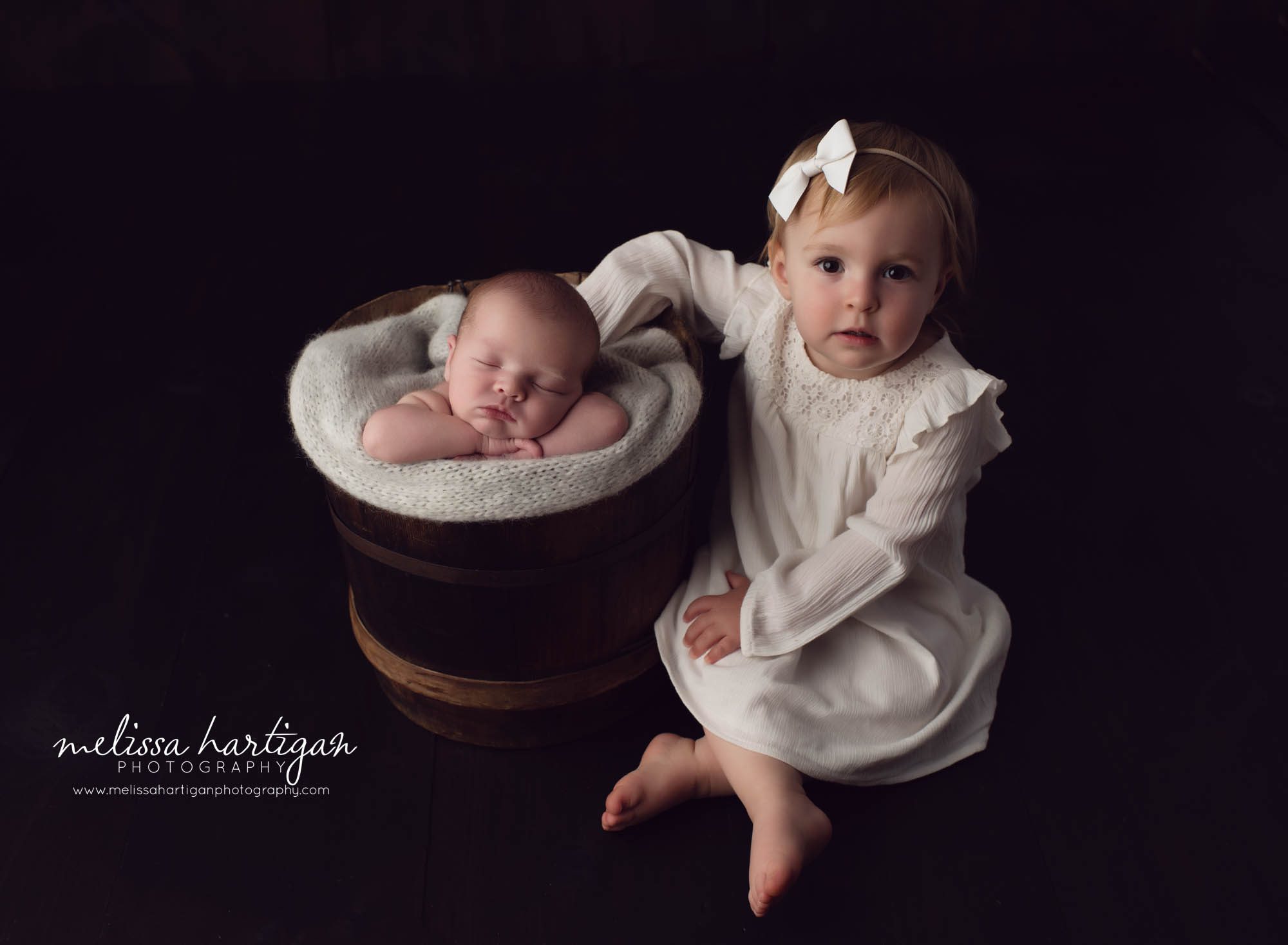 newborn boy posed in barrel with older sister sitting beside it Baby Photographer South Windsor CT