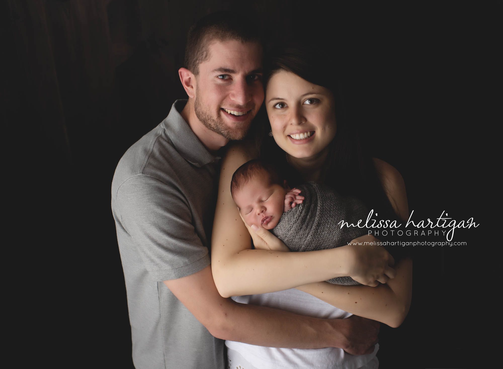 Newborn boy family pose baby photo session with mom dad baby wrapped