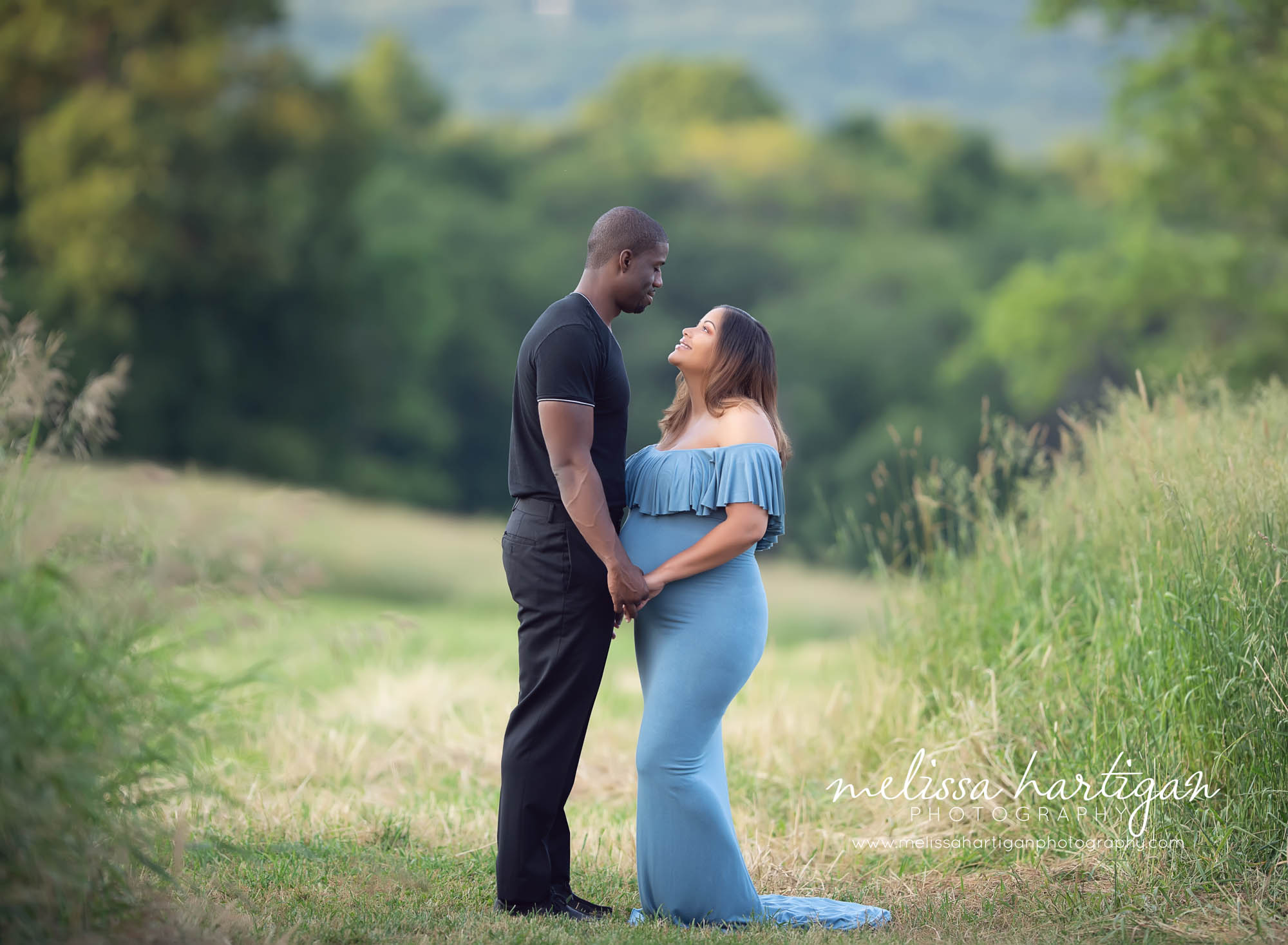 couple standing looking each other holding hands maternity photography CT