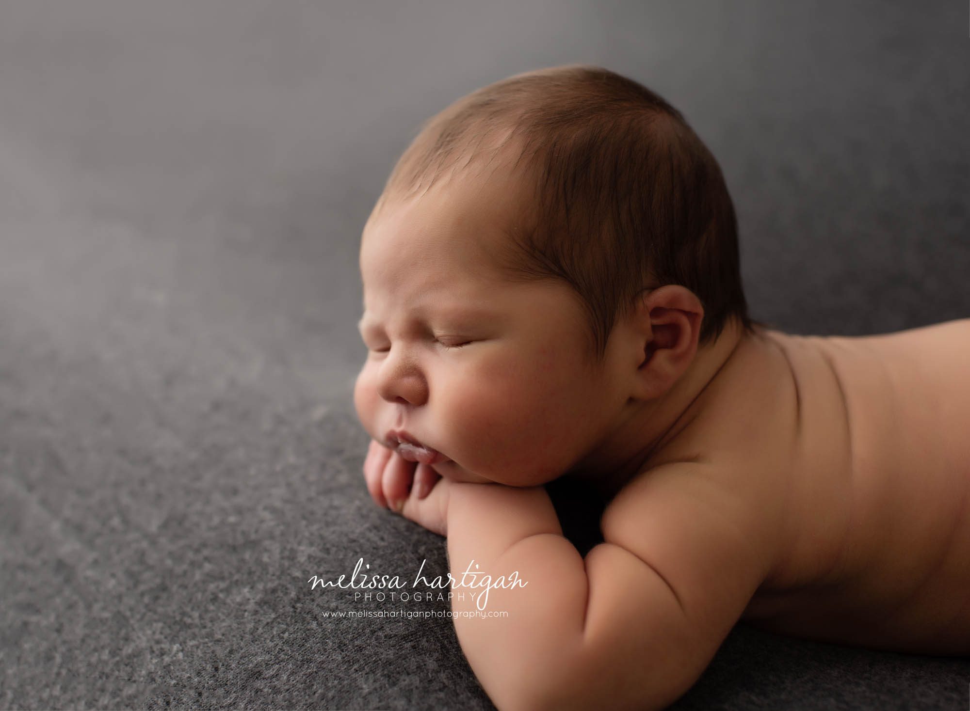 baby boy resting his head on his hands posed newborn photos CT Newborn photographers
