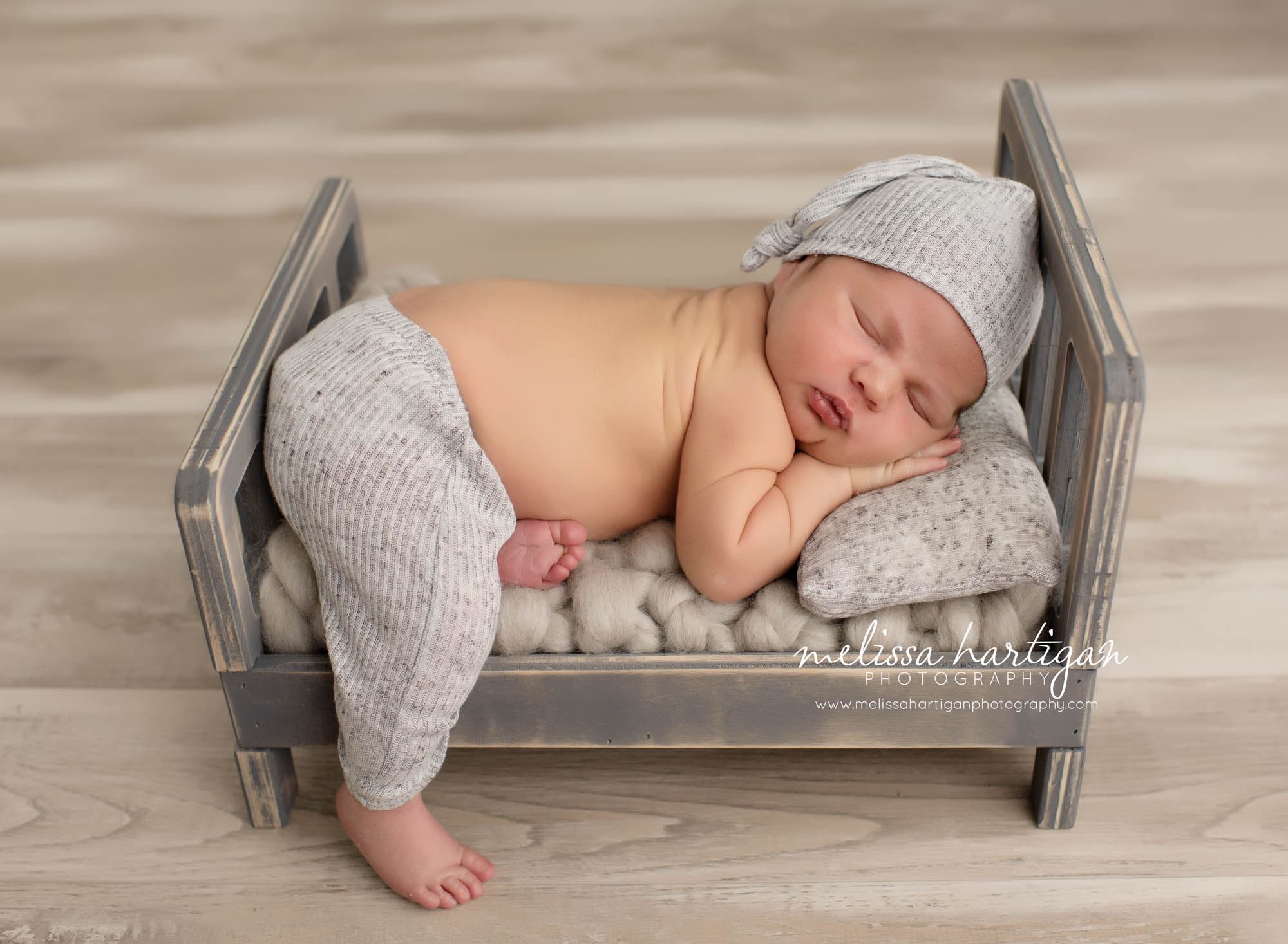 newborn boy wearing light grey pants and sleepy hate set baby photos Ellington CT newborn Photography