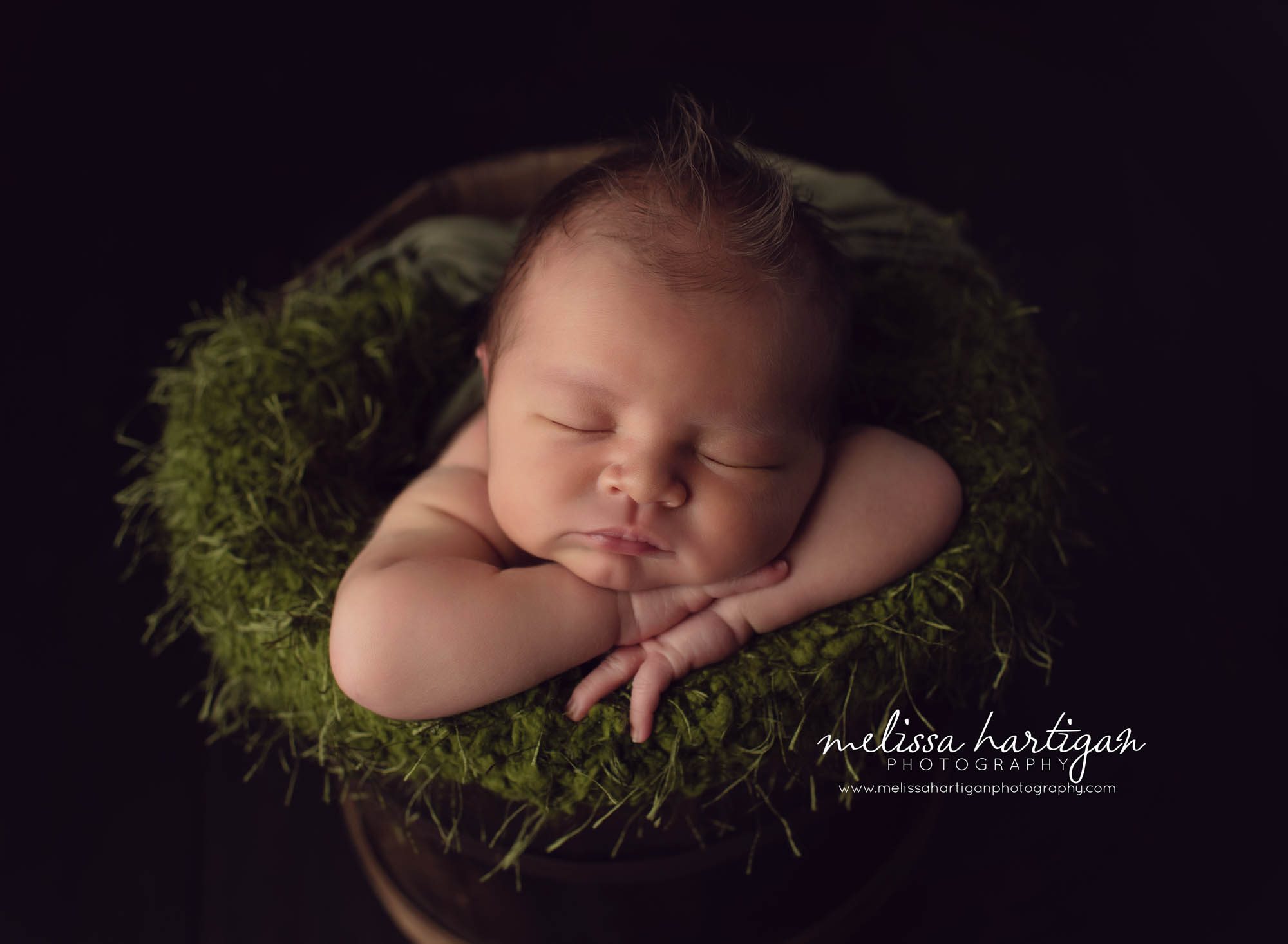 Baby boy posed in bucket with green color moss