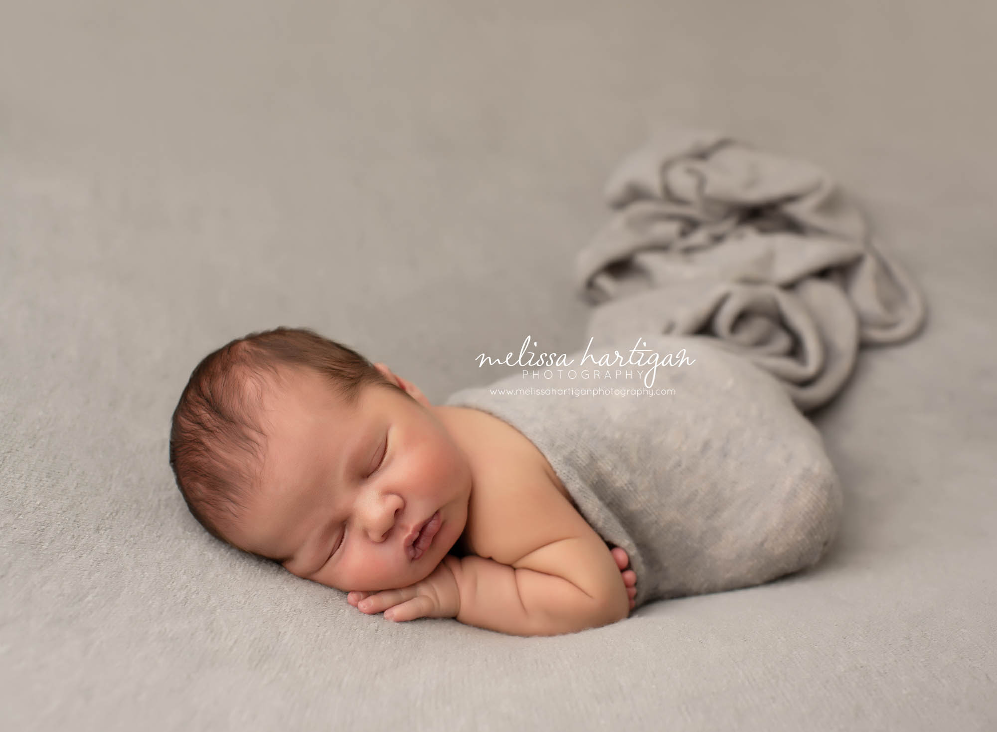 Baby boy sleeping on grey blanket with grey wrap posed newborn photos tolland county CT newborn photographers