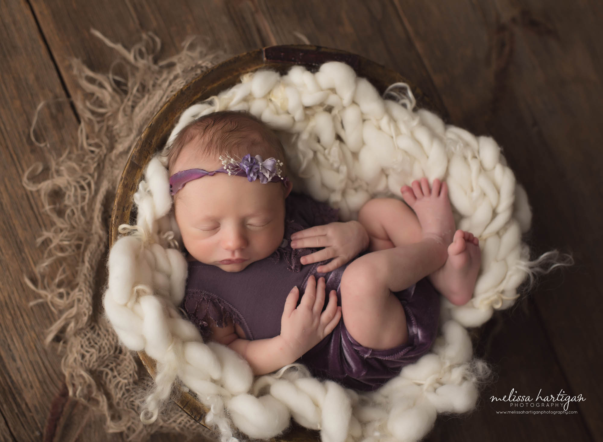 Baby girl posed in rustic bowl with chunky knitted layer