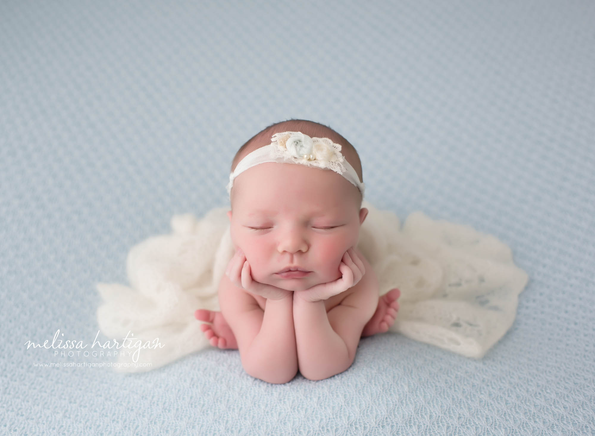 baby girl posed on blue backdrop with head in hands froggy pose newborn photography CT
