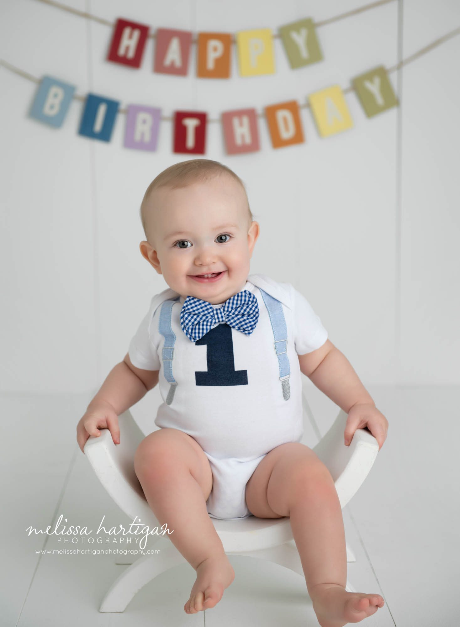 baby boy sitting on bench studio photo session happy birthday banner