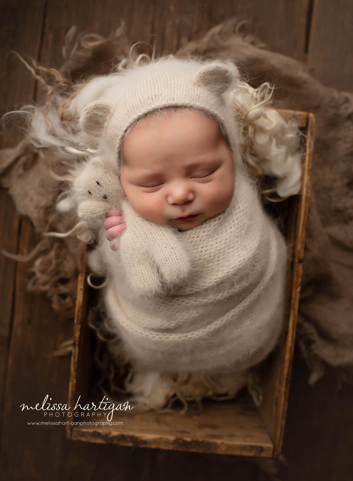 Baby boy neutral color knitted wrap bear bonnet with teddy posed in rustic crate CT newborn photographer