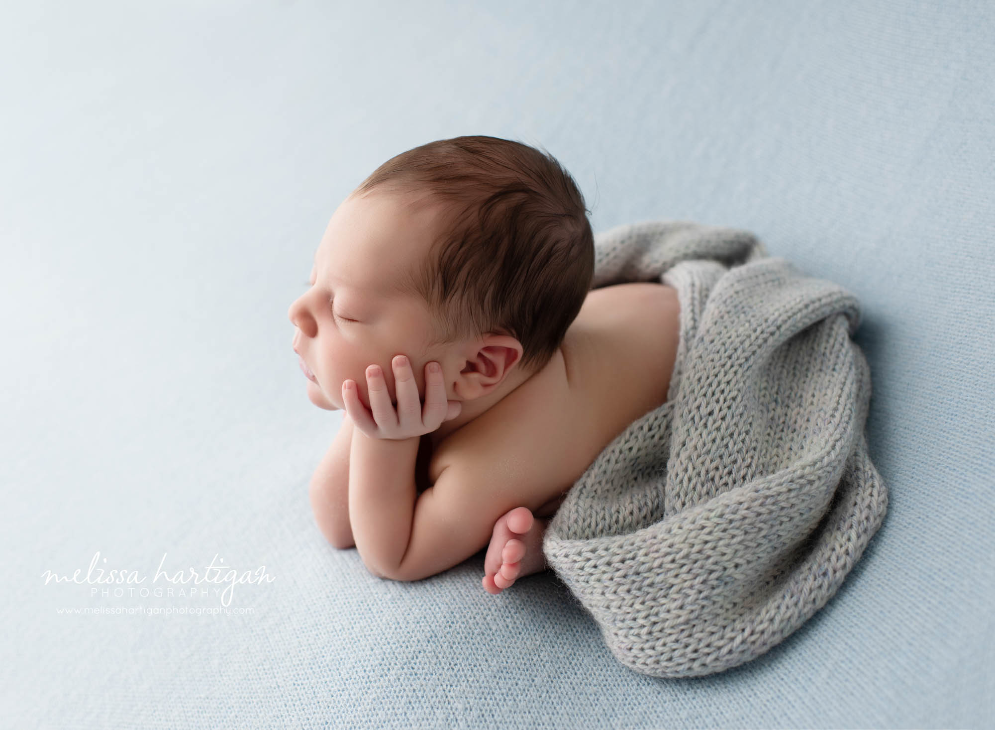 Baby boy posed with chin in hands side profile froggy pose shot East CT newborn photographer