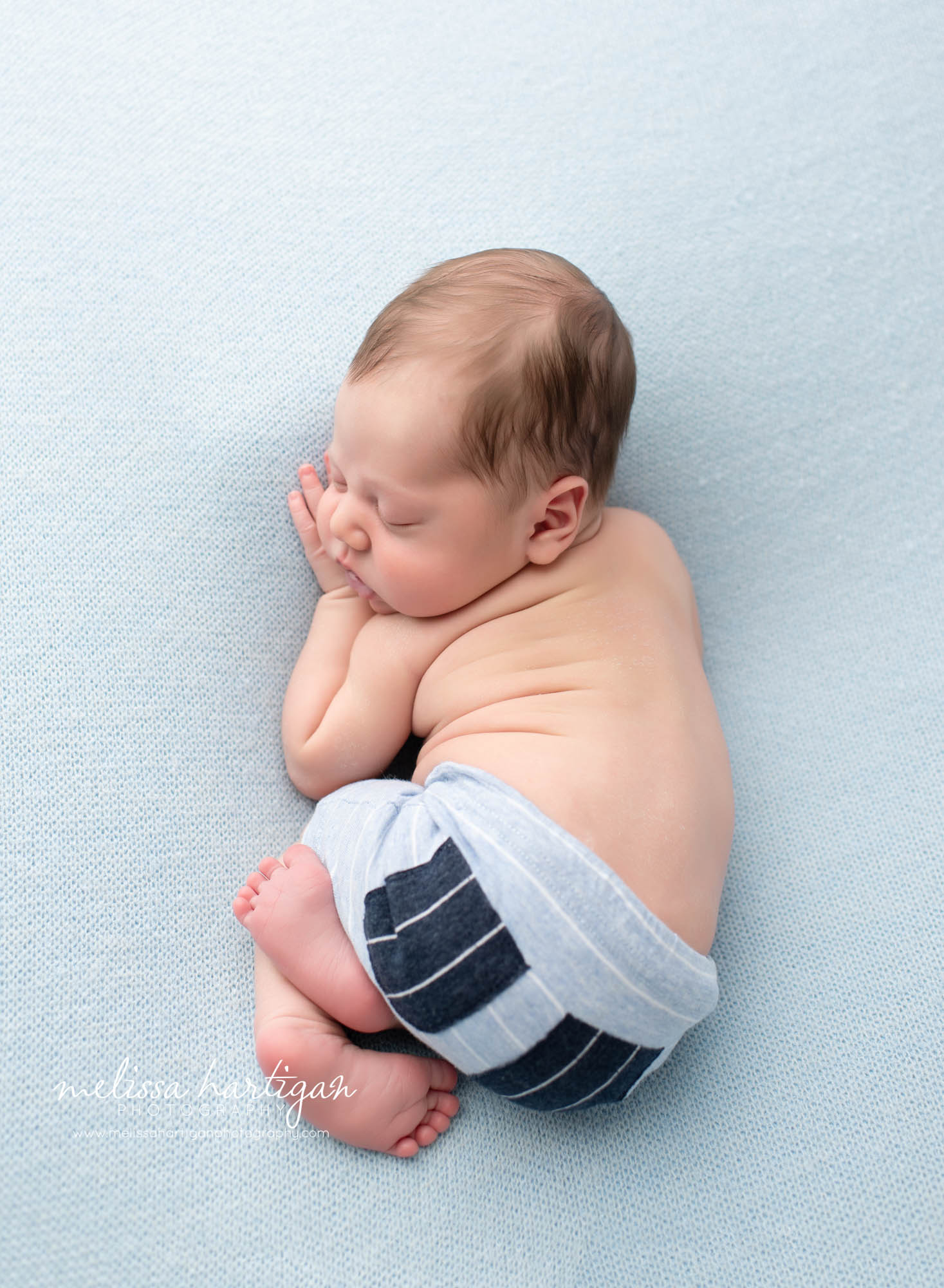 Baby boy wearing newborn pants posed on tummy Eastern CT Newborn Photographer