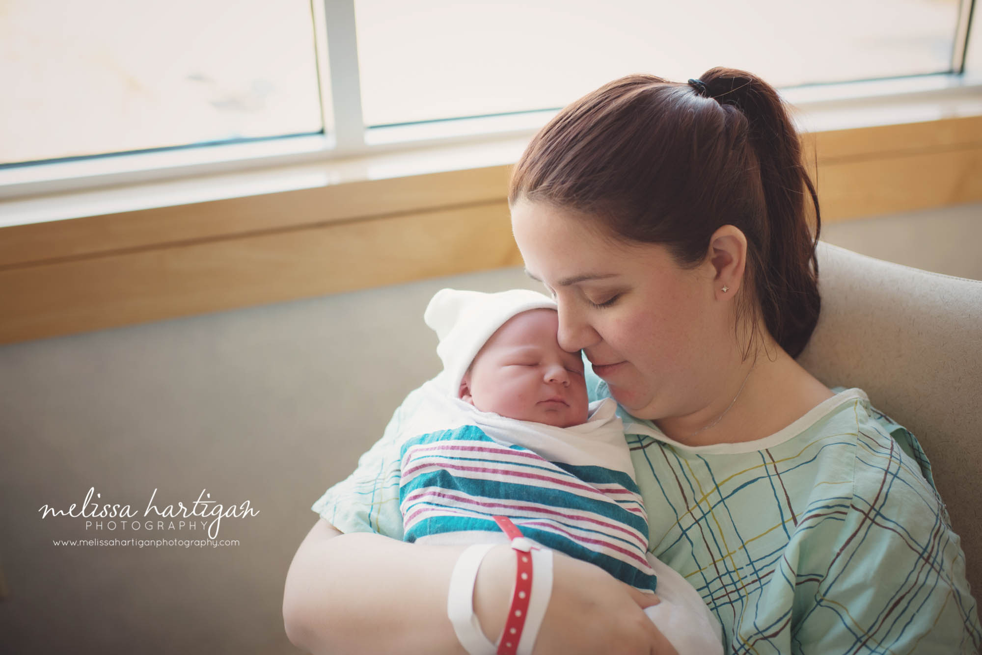 mom and newborn baby snuggling at hospital