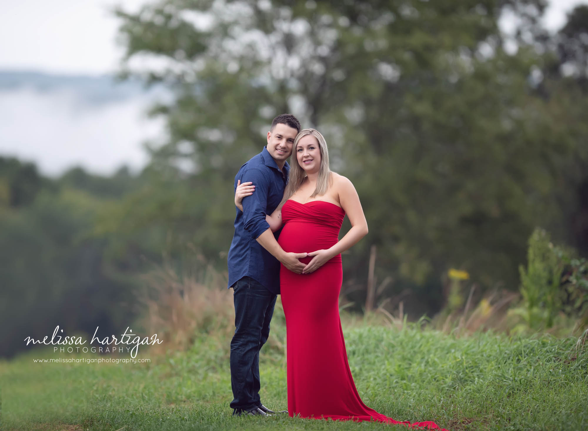 expectant couple standing holding baby bump