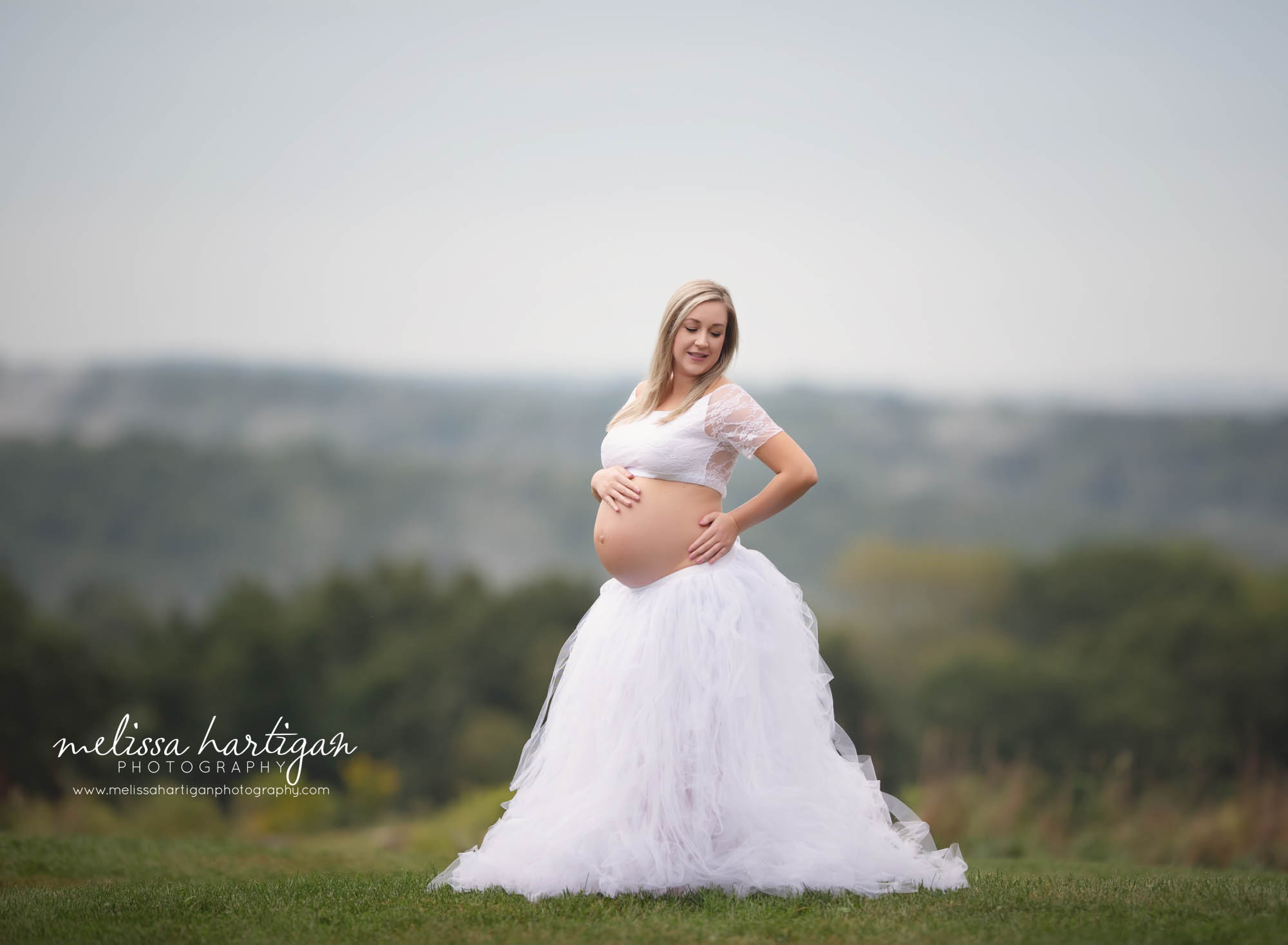 mom to be holding to baby bump wearing lace top with tulle skirt CT maternity Photographer