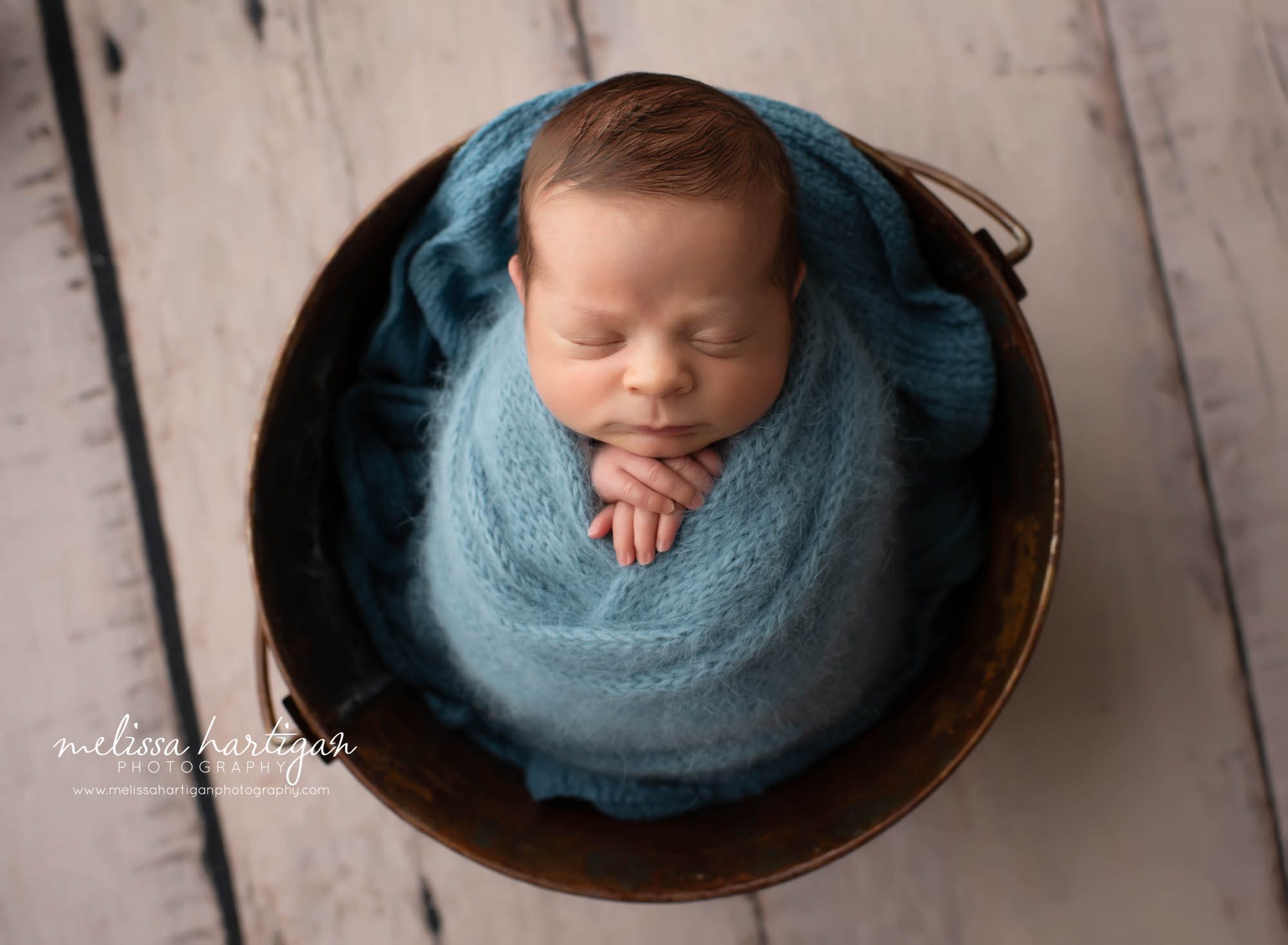 Baby boy posed in metal bucket on back wrapped in knitted blue wrap CT Newborn Photography
