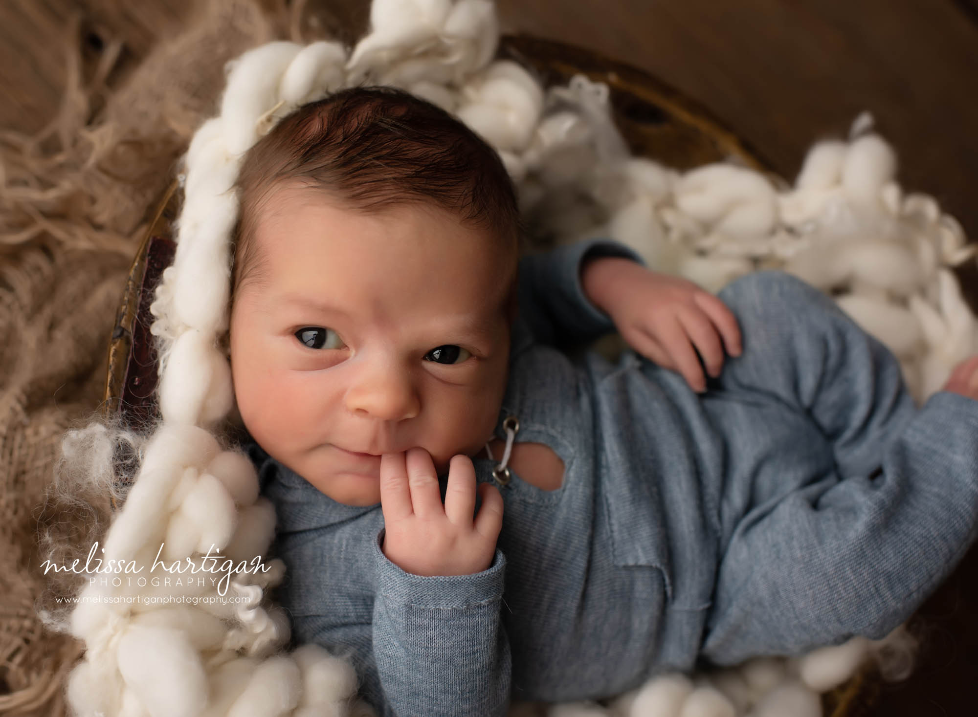 baby boy posed in bowl with cream colored fluff layer and blue newborn outfit newborn photography CT coventry