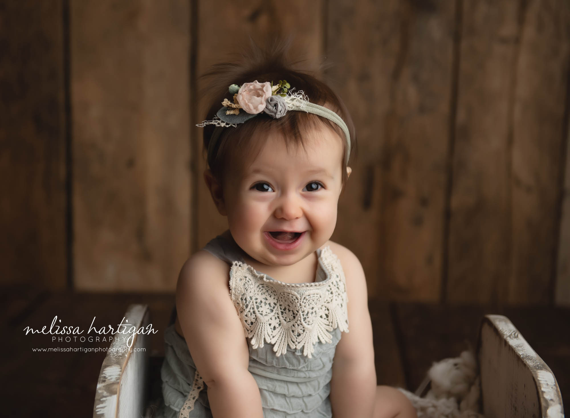Baby girl sitting in wooden prop smiling at camera CT baby Photography