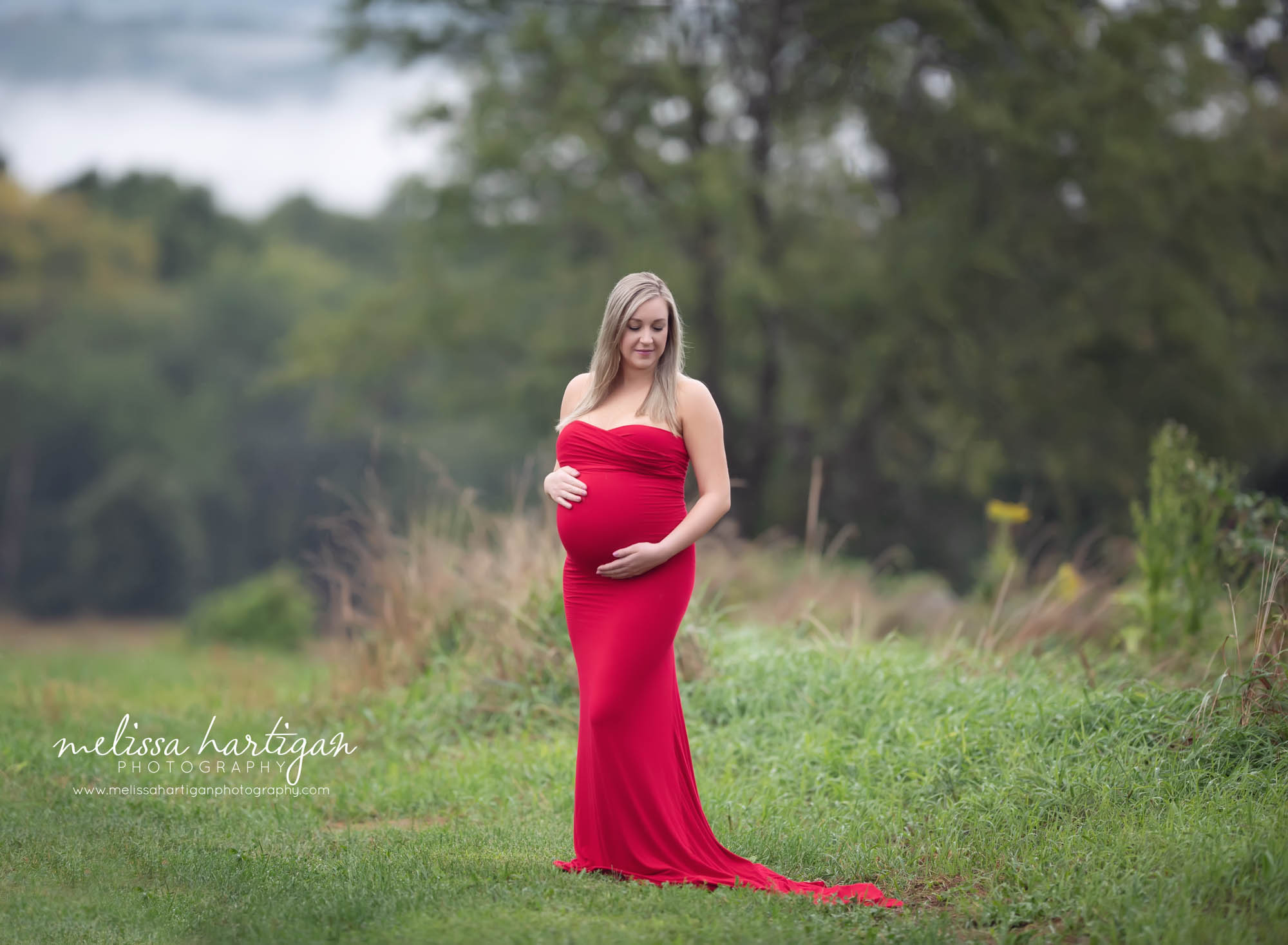 expectant mom wearing red dress holding her baby bump Ct maternity photographer