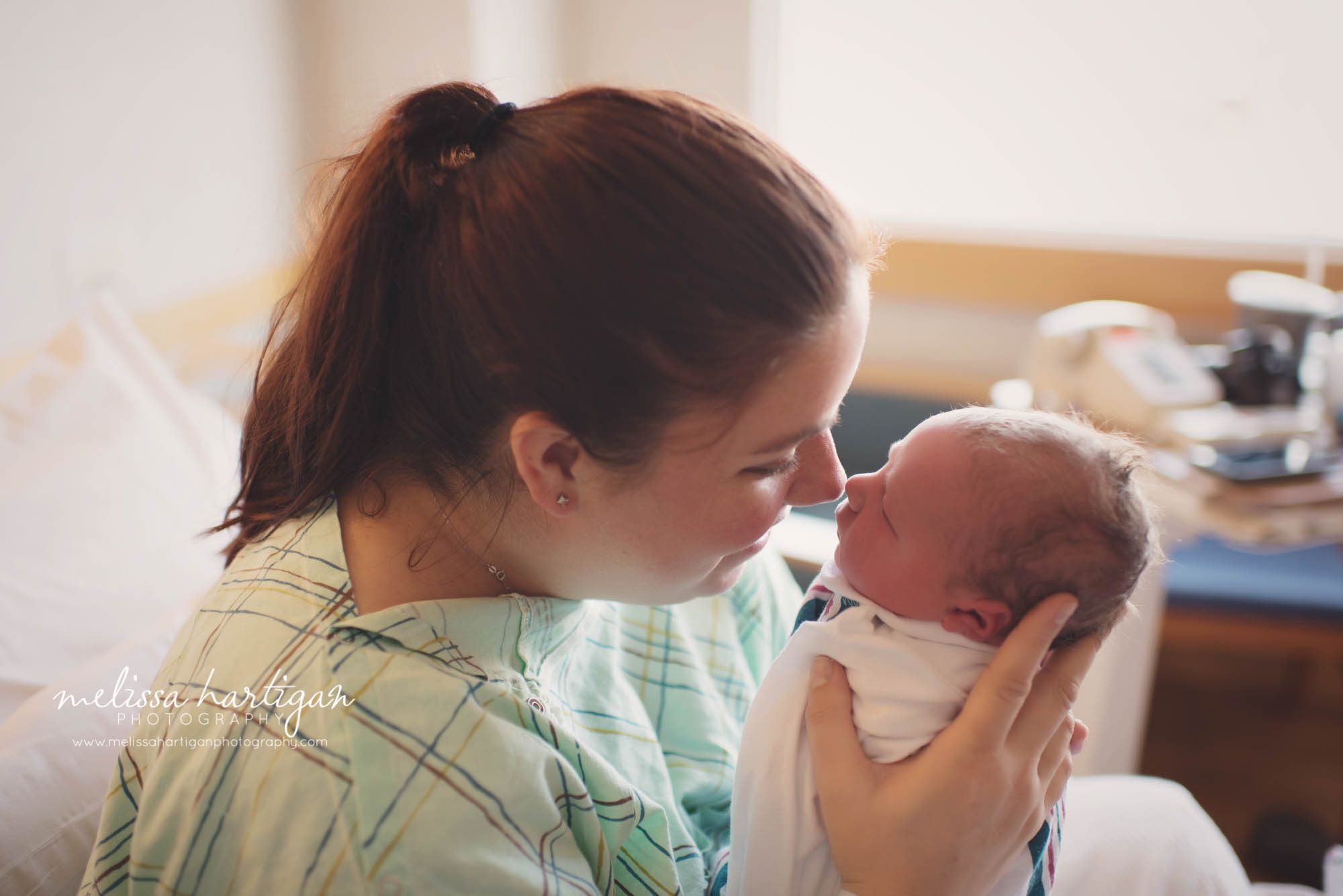 mom holding newborn baby close to her face