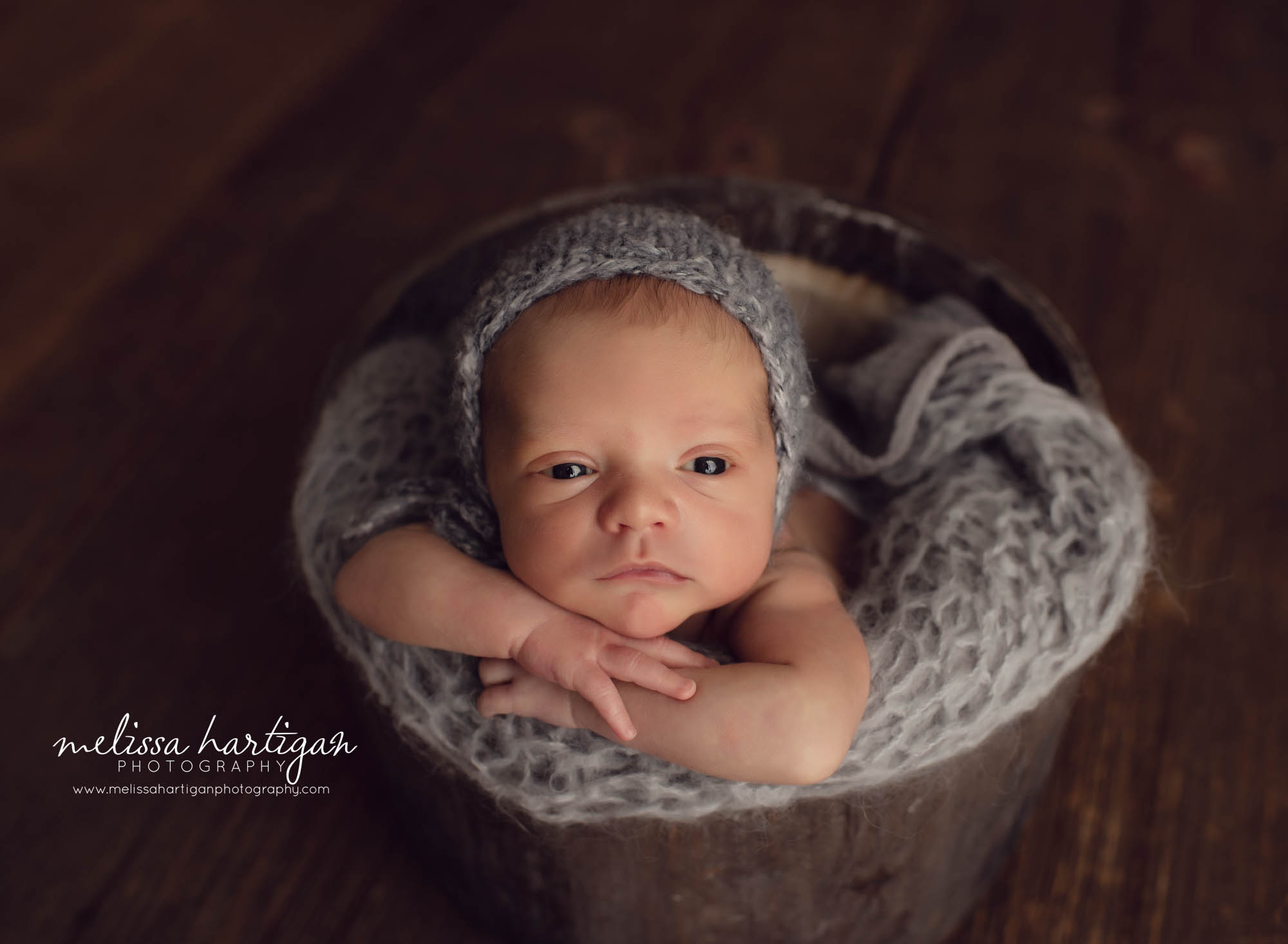 baby boy posed in bucket with grey knitted bonnet and knitted chunky layer awake newborn baby photo Tolland County CT Newborn Photography