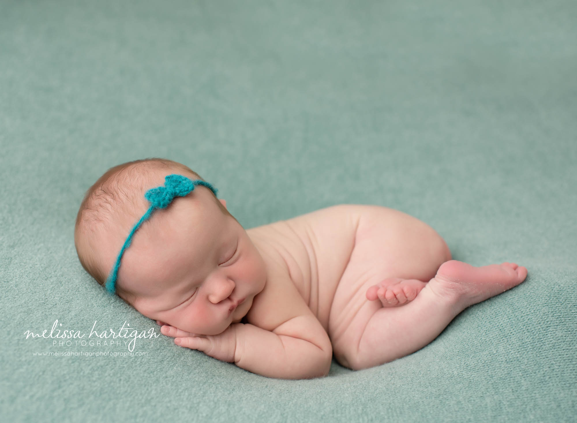 Baby girl posed on tummy with hand under cheek CT newborn photography