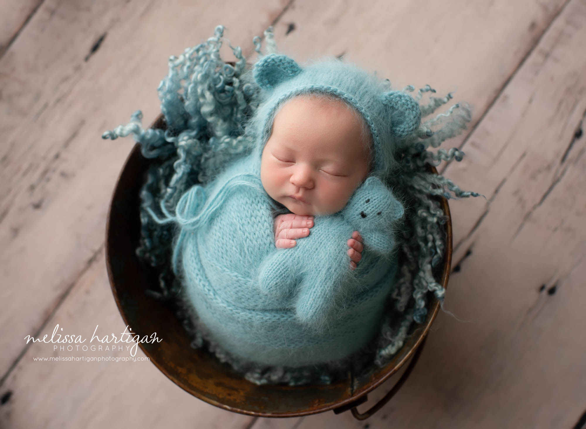 Baby girl wrapped in teal colored knitted wrap with matching bear bonnet and teddy bear Ellington CT newborn photography