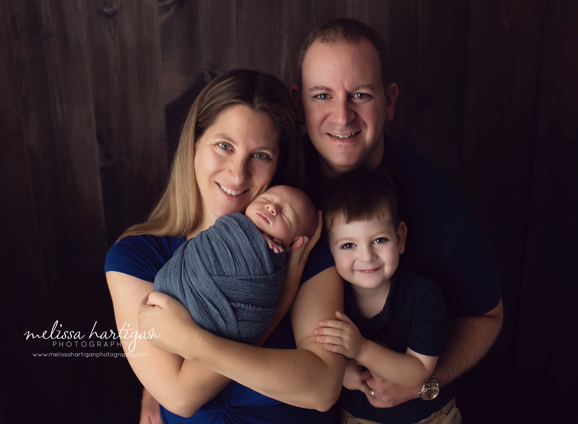 mom, dad, older brother and newborn baby boy family pose