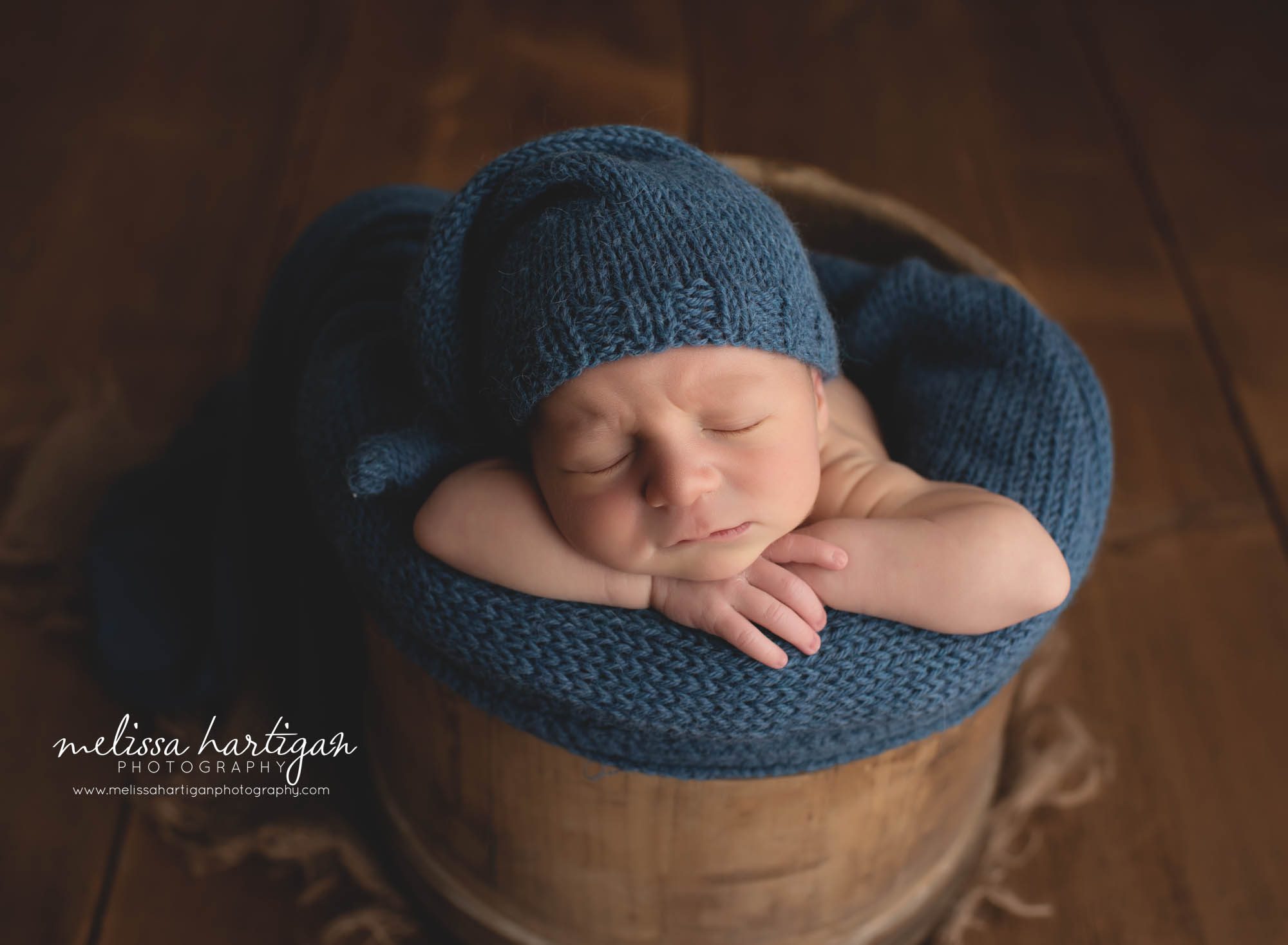 newborn baby boy posed in bucket with navy blue