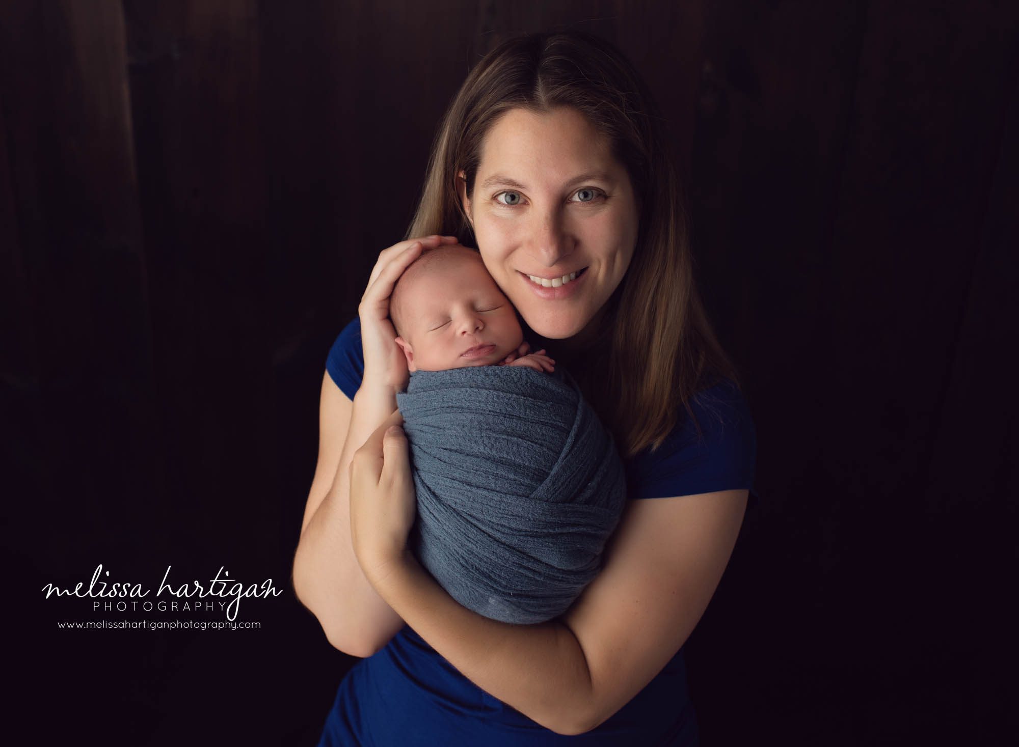 mom and newborn baby boy wrapped in blue wrap newborn photography