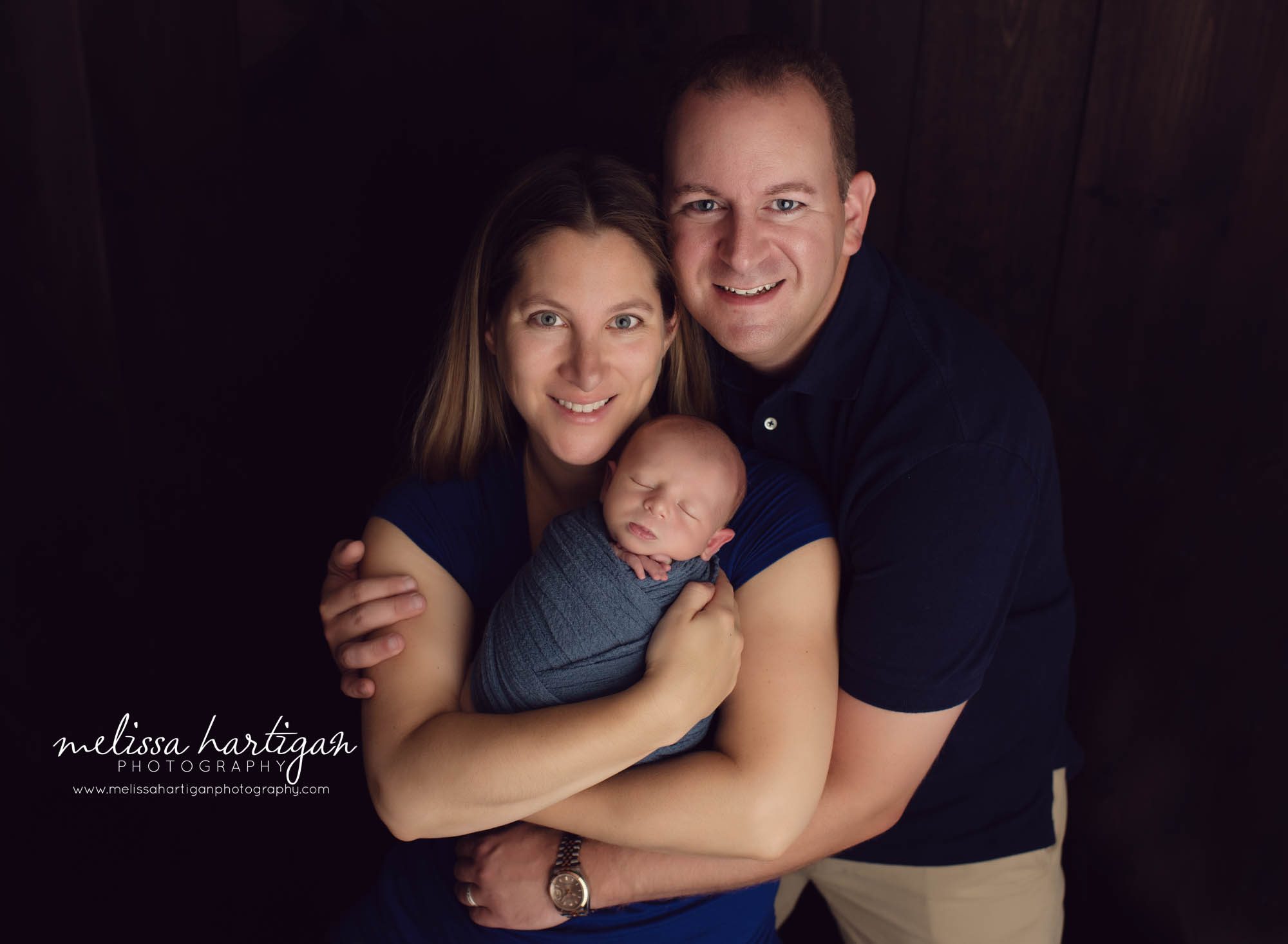 Mom, Dad and newborn baby boy family pose studio newborn photography