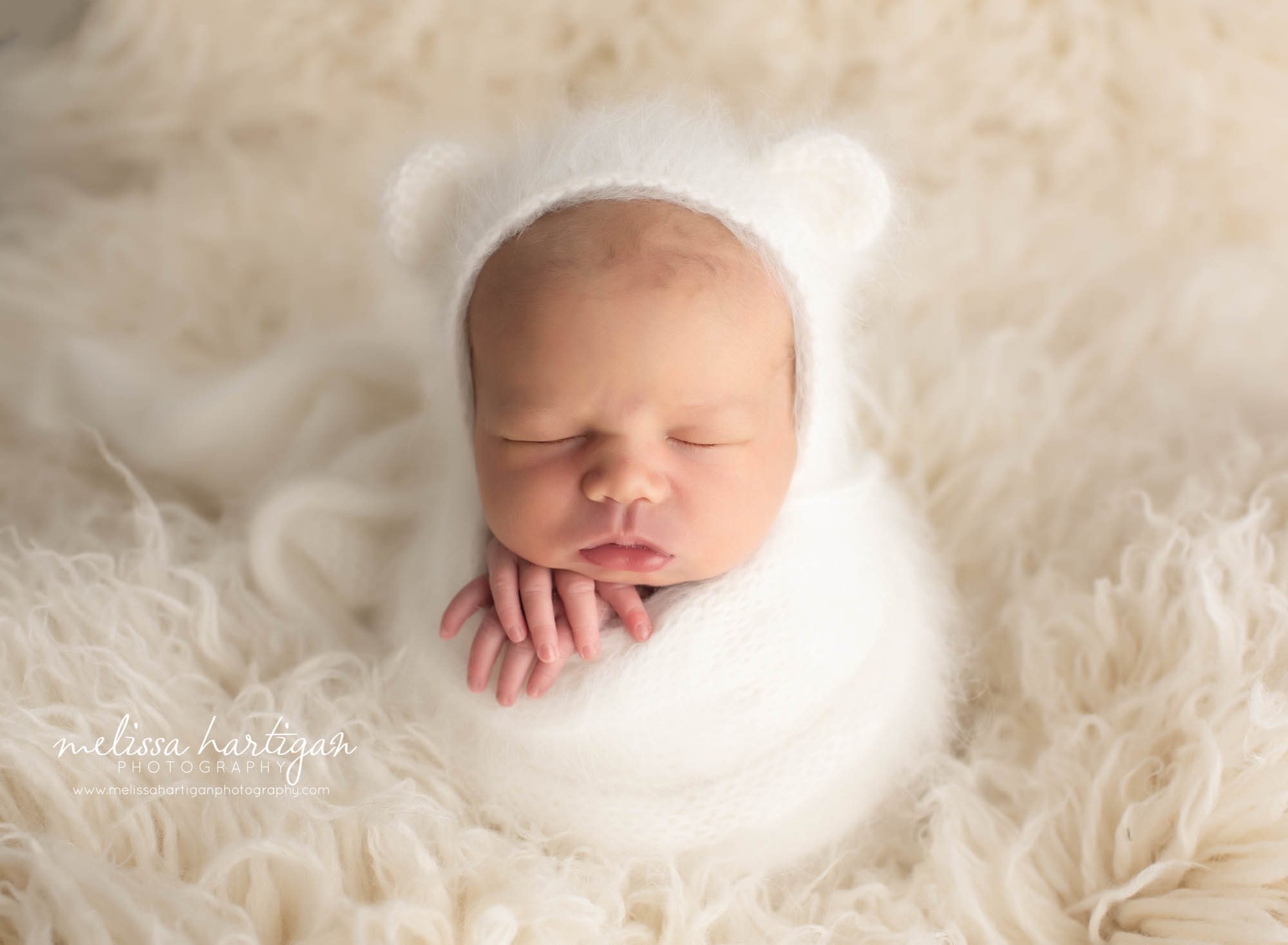 Baby girl wrapped in white on white flokati Newborn Photographer CT