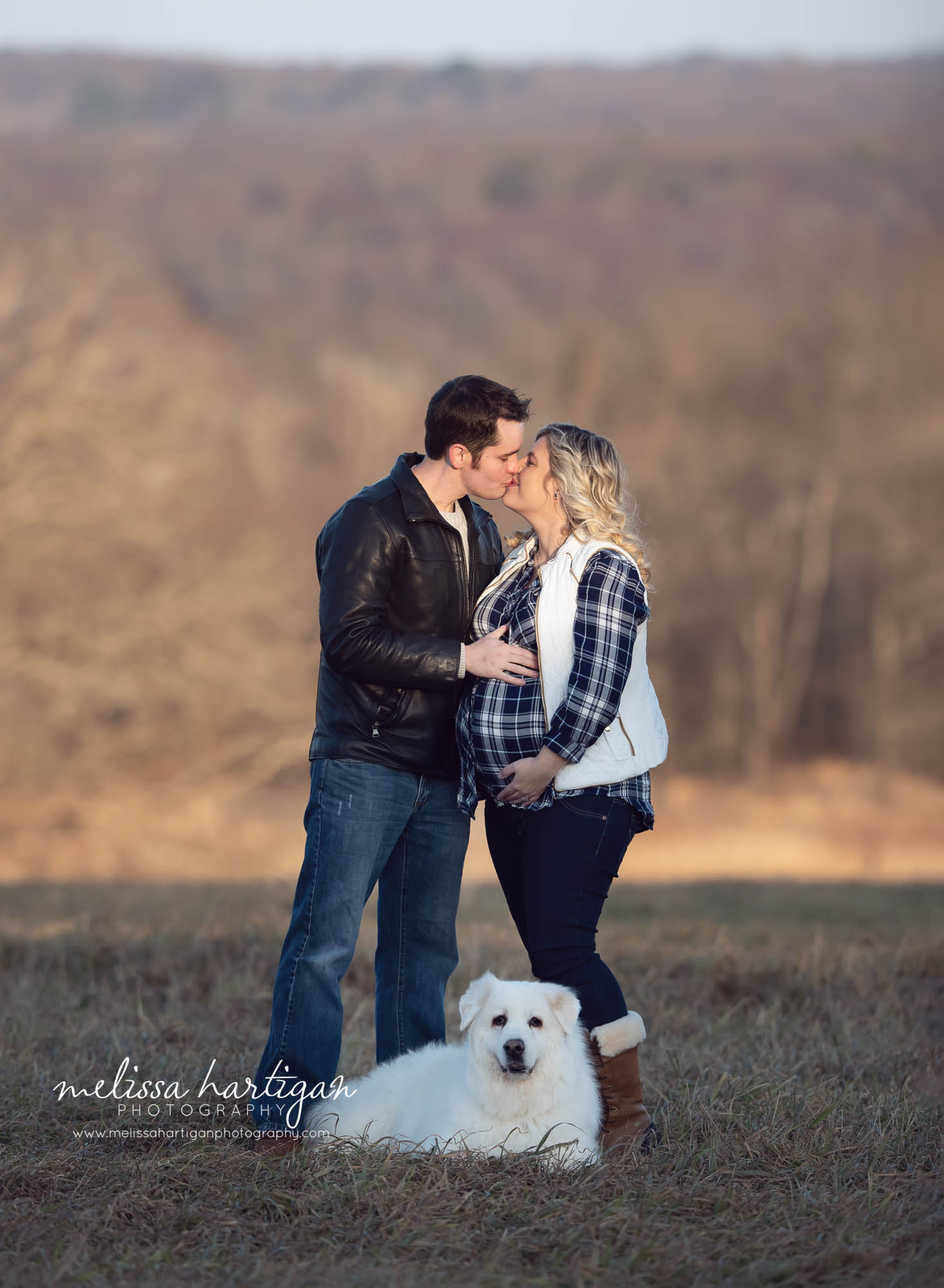 Couple kissing with down laying at feet maternity pictures CT maternity Photography