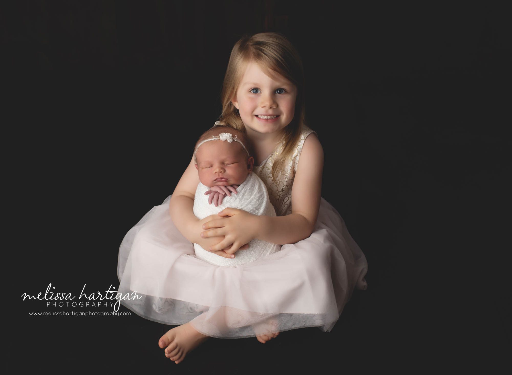 Older sister holding baby sister studio newborn photography session CT newborn photographer