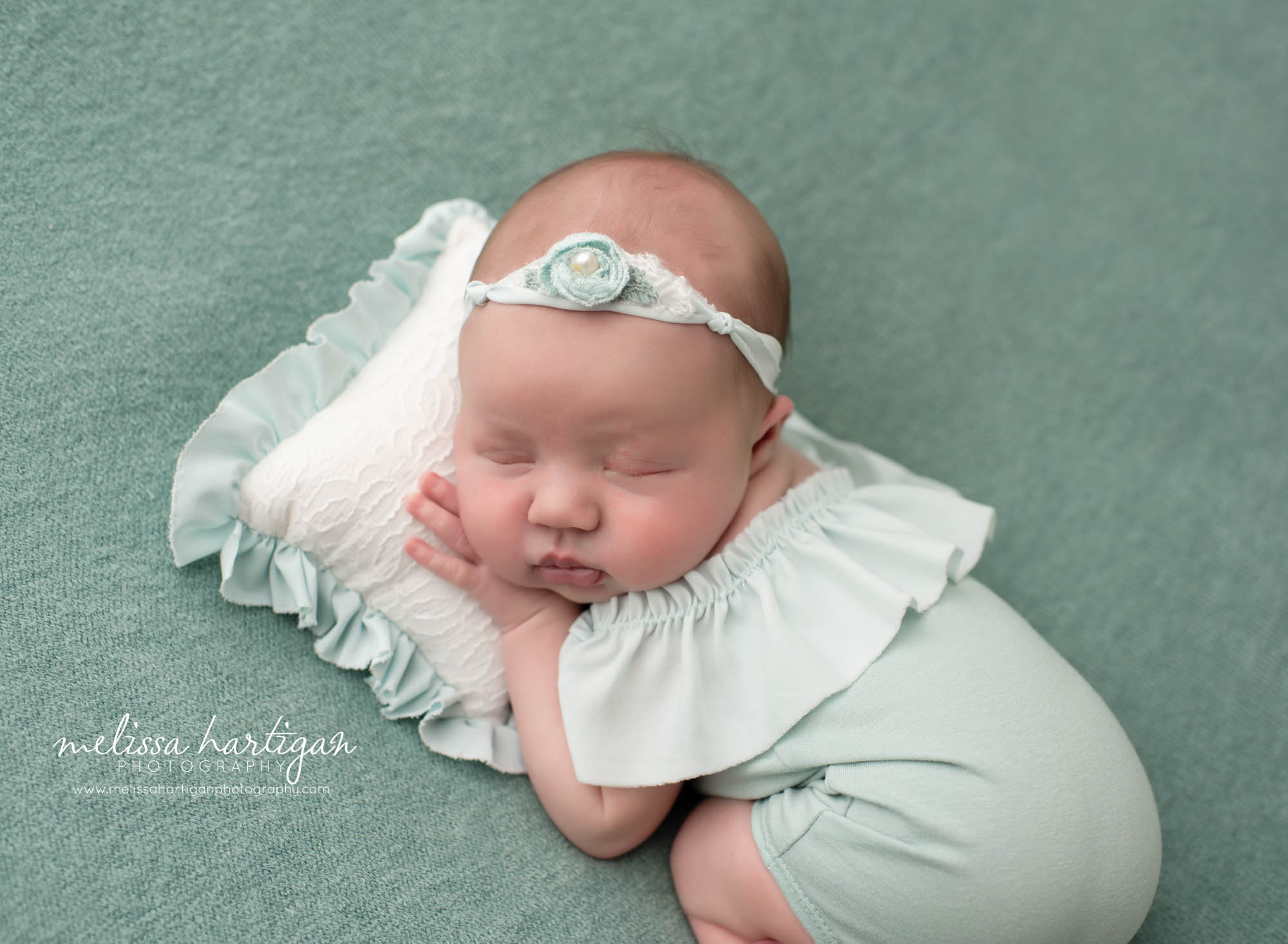 baby girl posed on newborn sized pillow with ruffles and mint green newborn outfit Stafford CT newborn Photographer