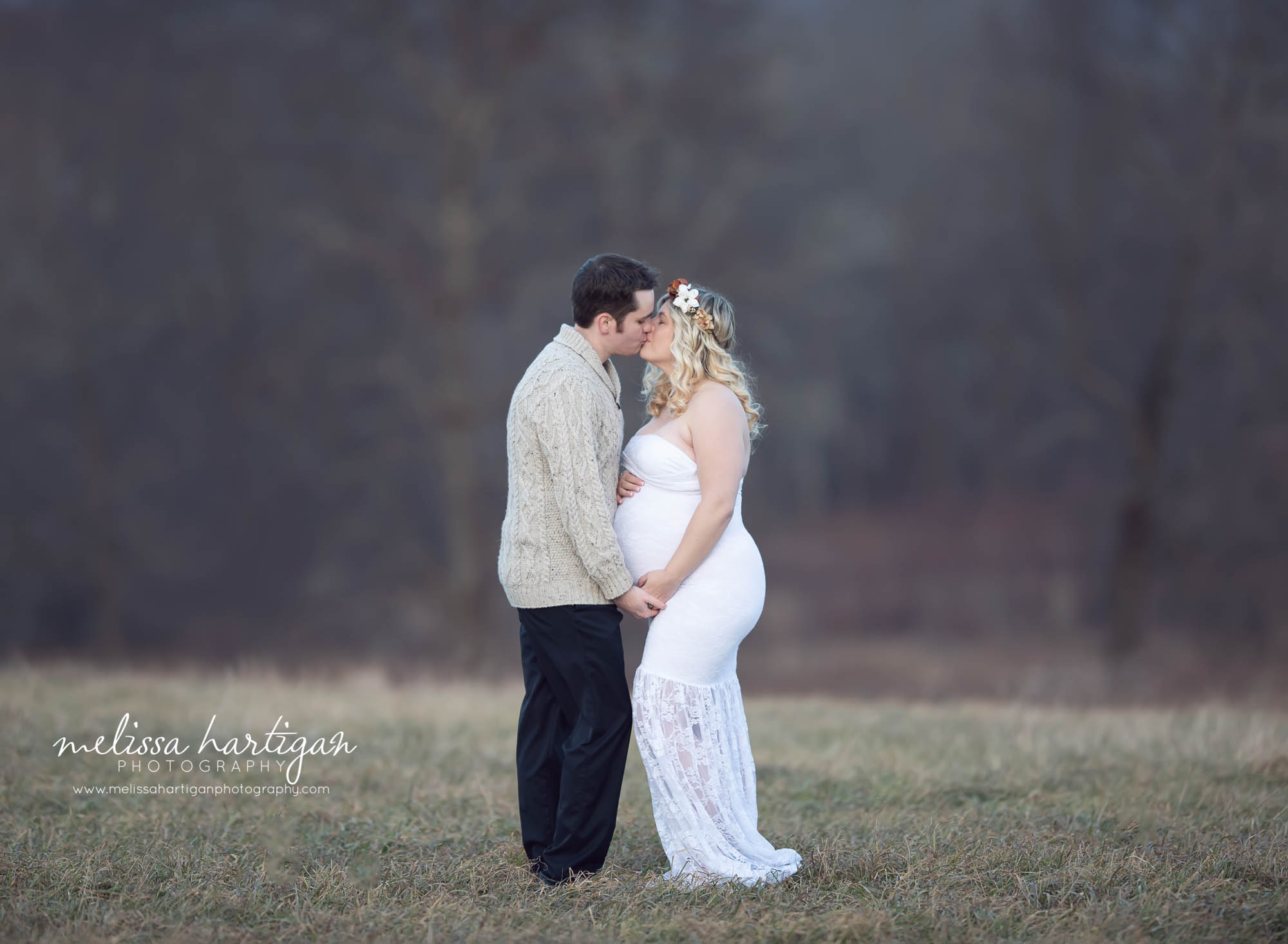 couple sharing a kiss mom holding her baby bump CT maternity photography