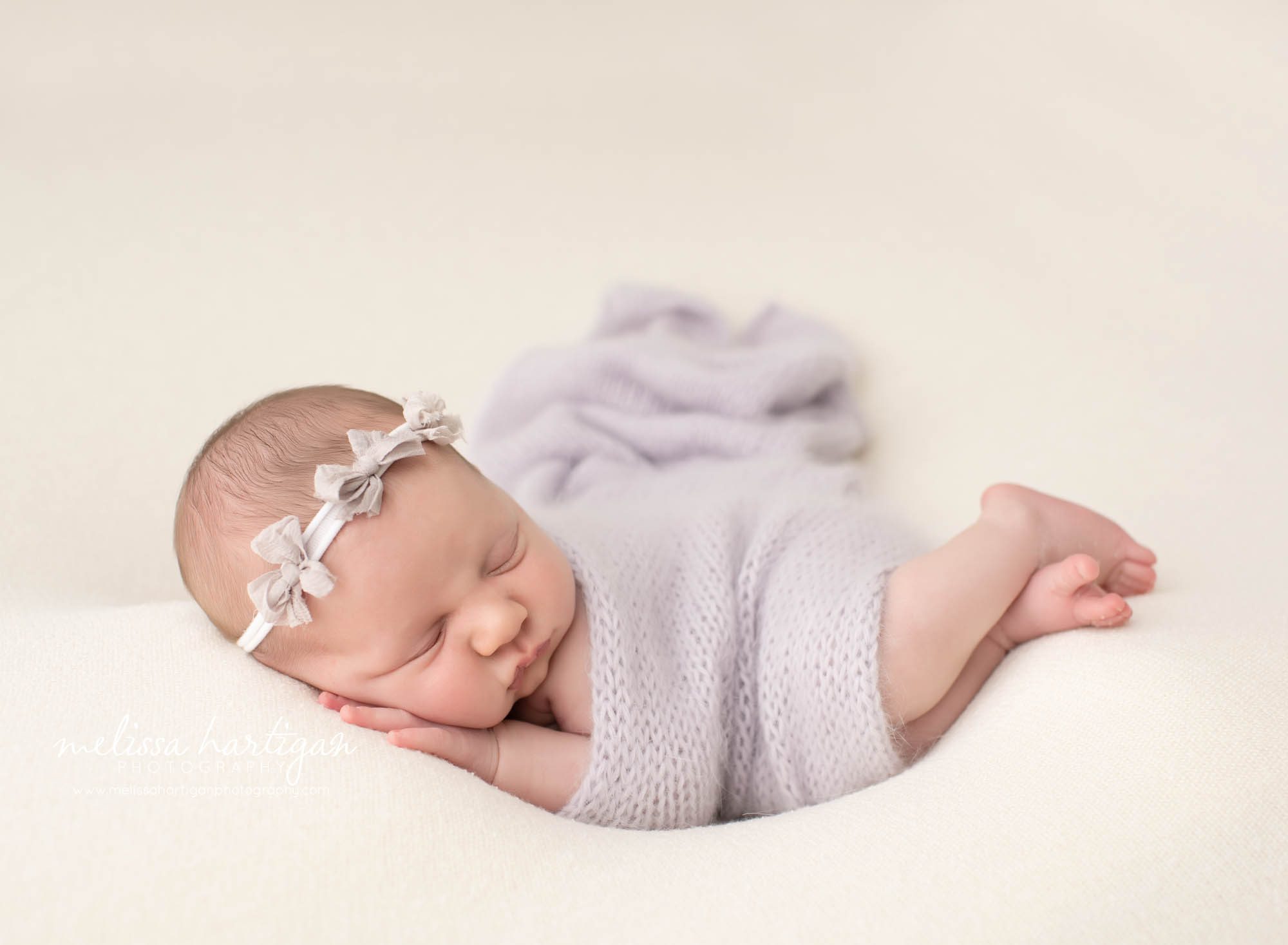 baby girl posed on side with light purple lilac knitted wrap and purple bow headband Newborn Photography CT