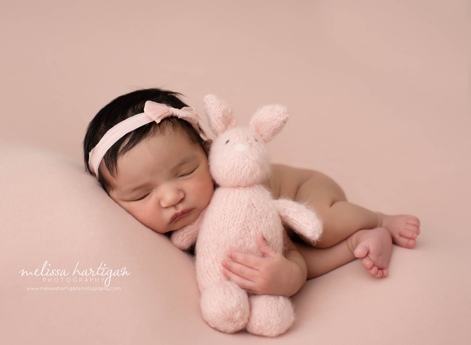 Baby girl posed with knitted pink bunny CT newborn photographers