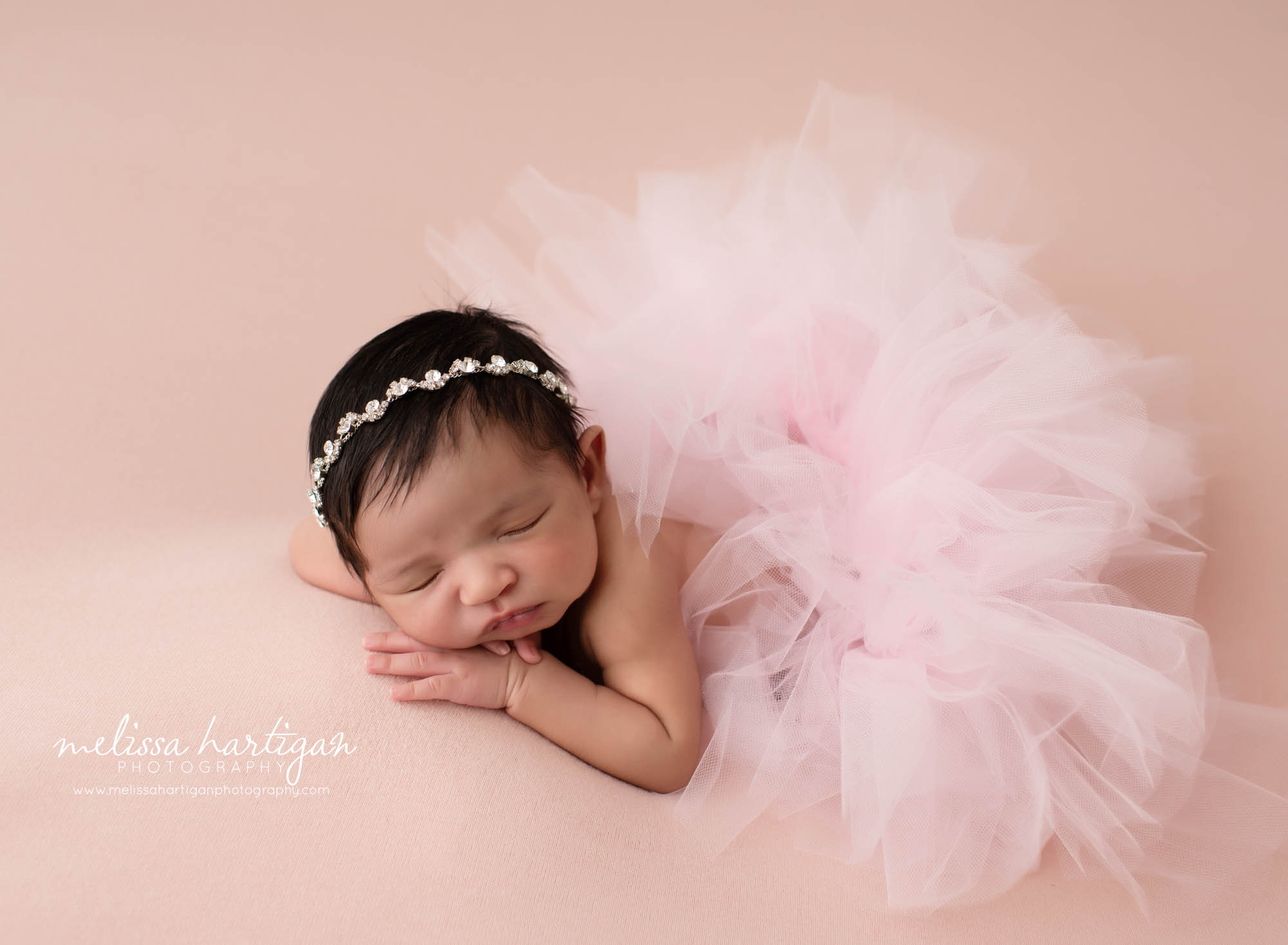 Baby girl posed on pink backdrop with pink tulle skirt