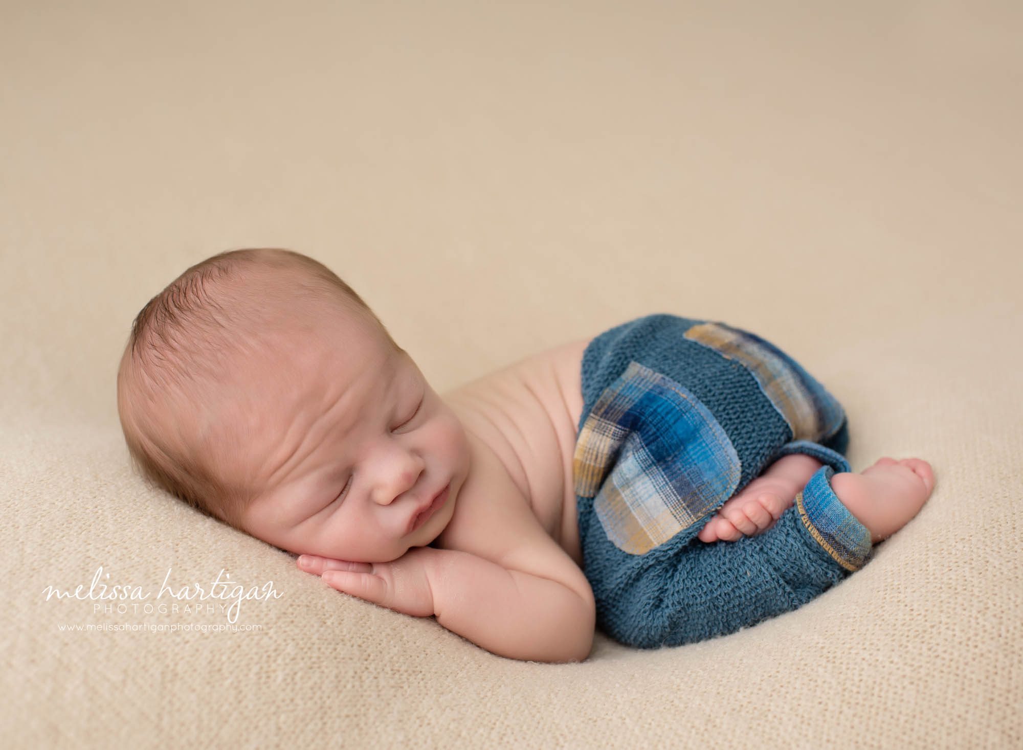 baby boy posed on tummy with bum up wearing newborn pants