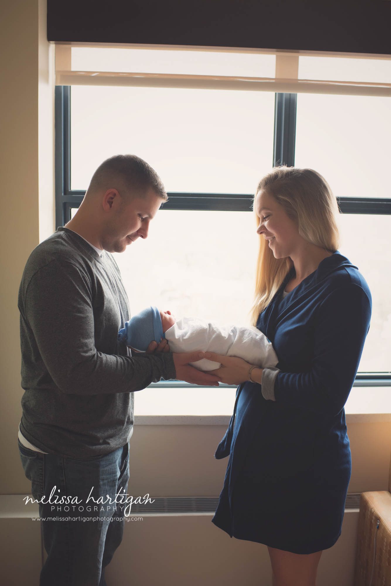 new parents share a moment holding their new baby Newborn Photography CT