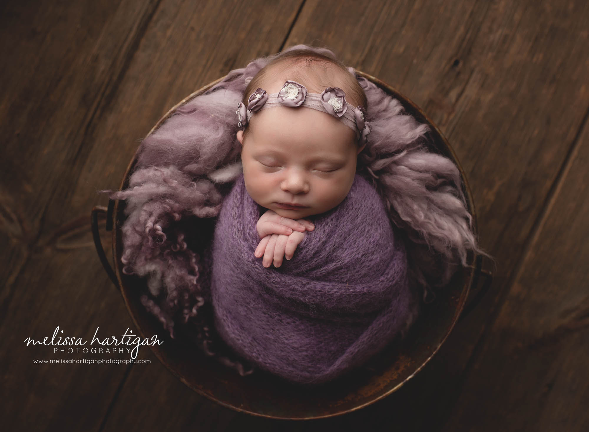 Baby girl wrapped in purple with curly layer and purple flower headband