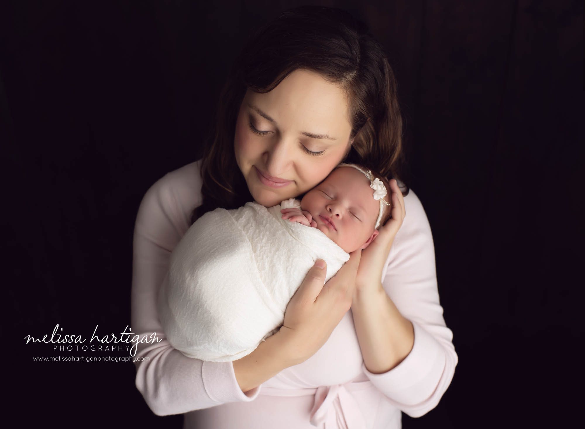 mom holding newborn baby girl studio newborn photography pose