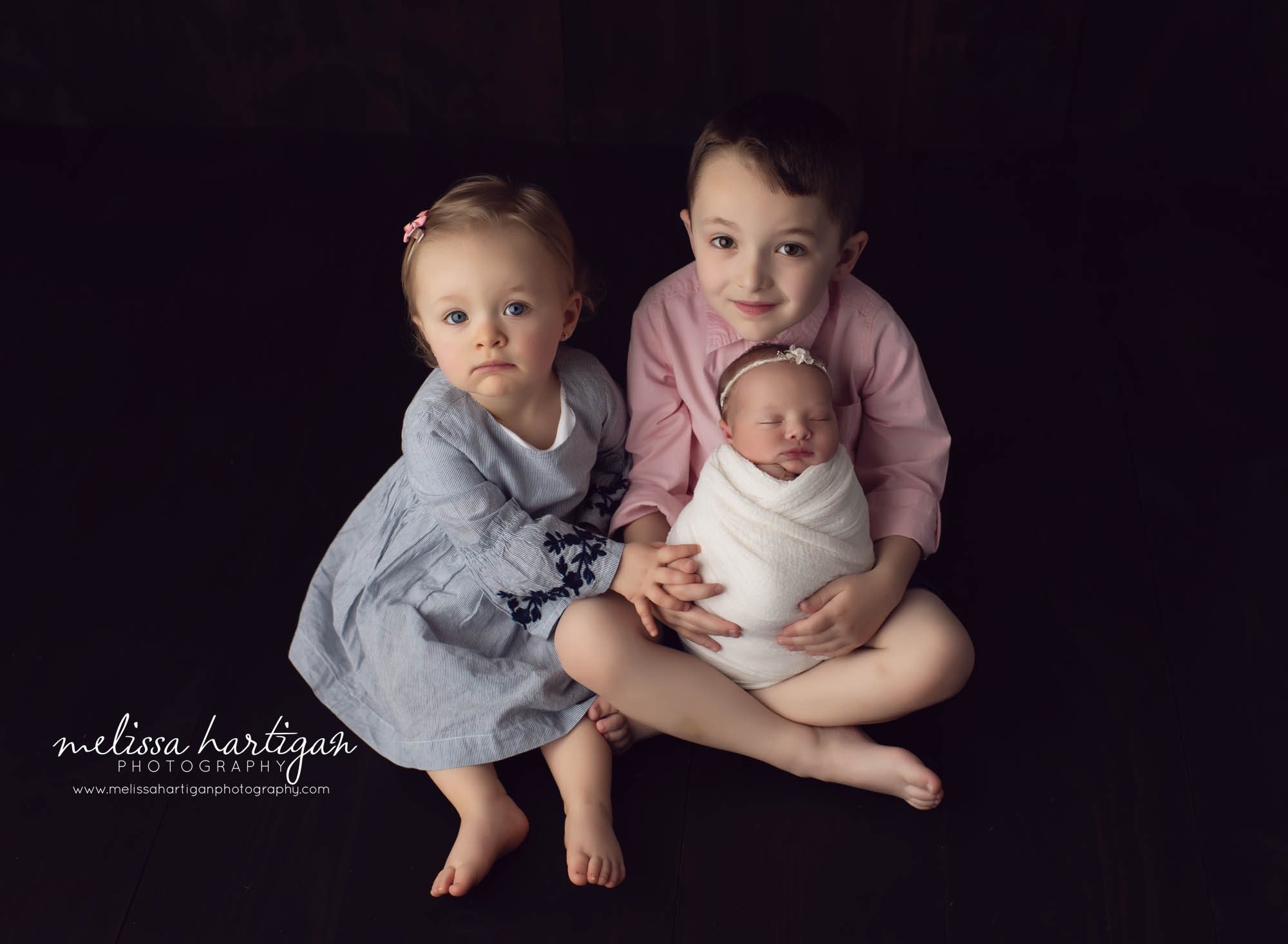 sibling photo posesitting down with baby and two older siblings
