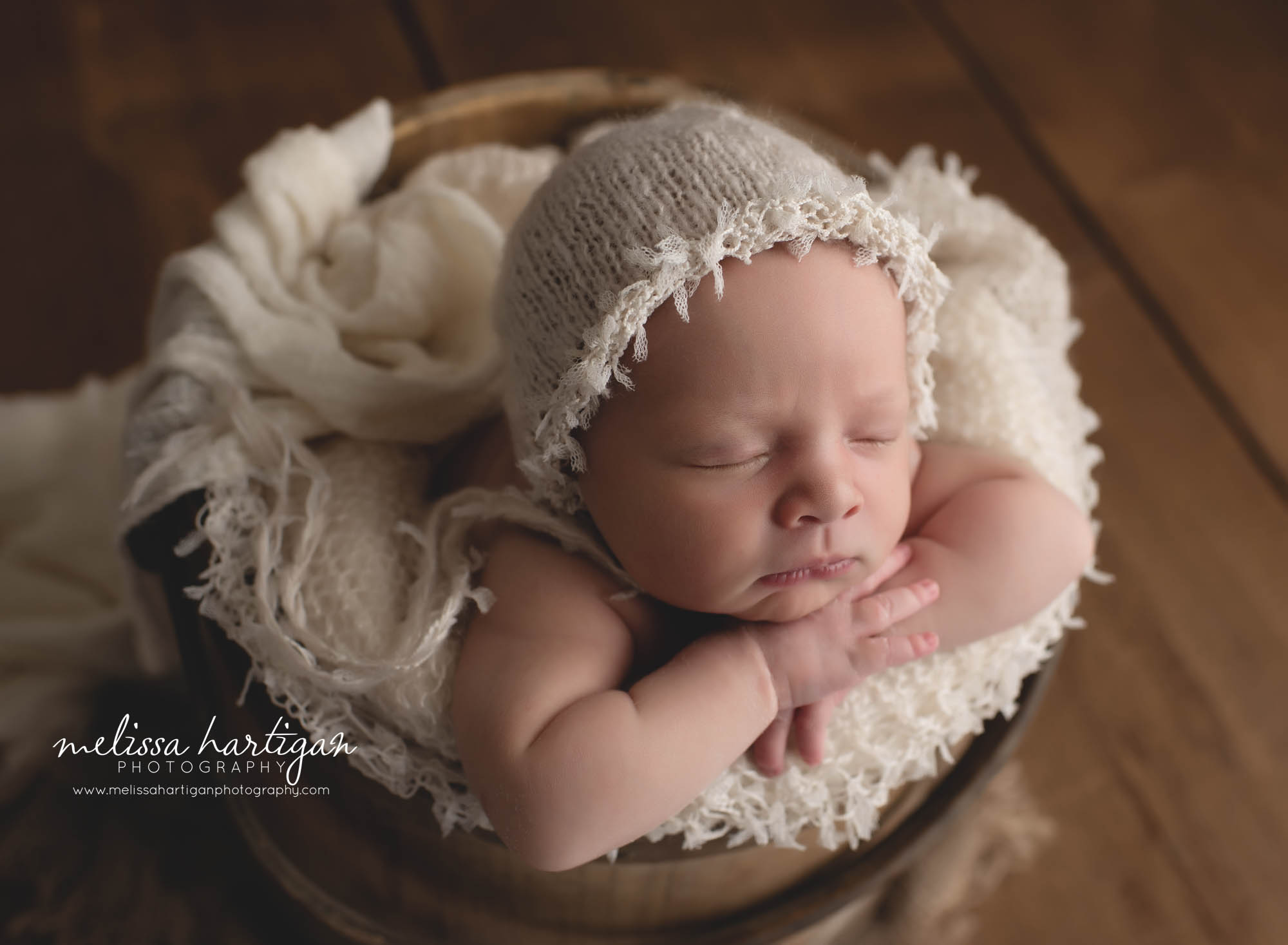baby girl posed in wooden rustic bucket with cream fringed bonnet side profile CT newborn photography