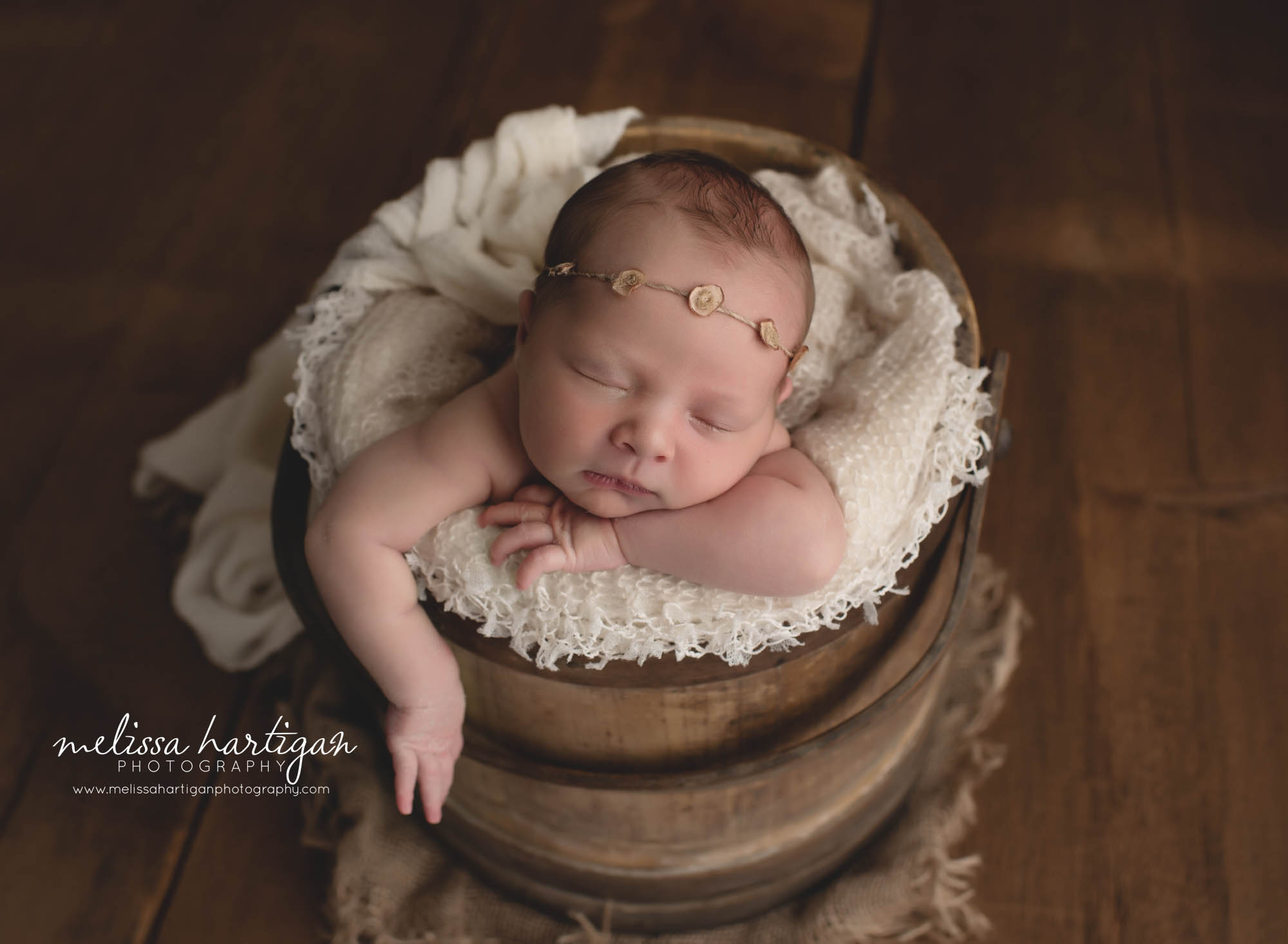 baby girl posed in wooden rustic bucket with headband and cream colored fringed layer