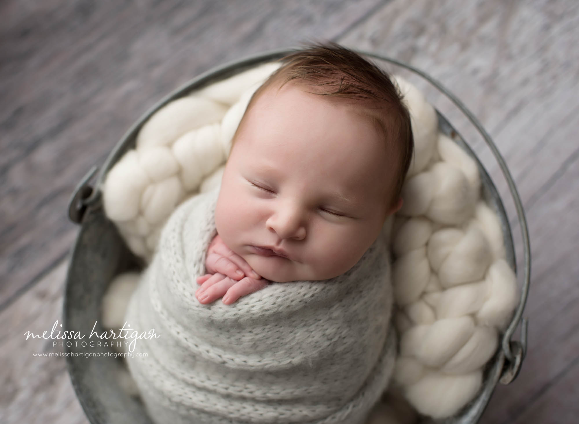 baby boy posed in metal bucket laying on back wrapped in gray knitted wrap west suffield ct newborn photography