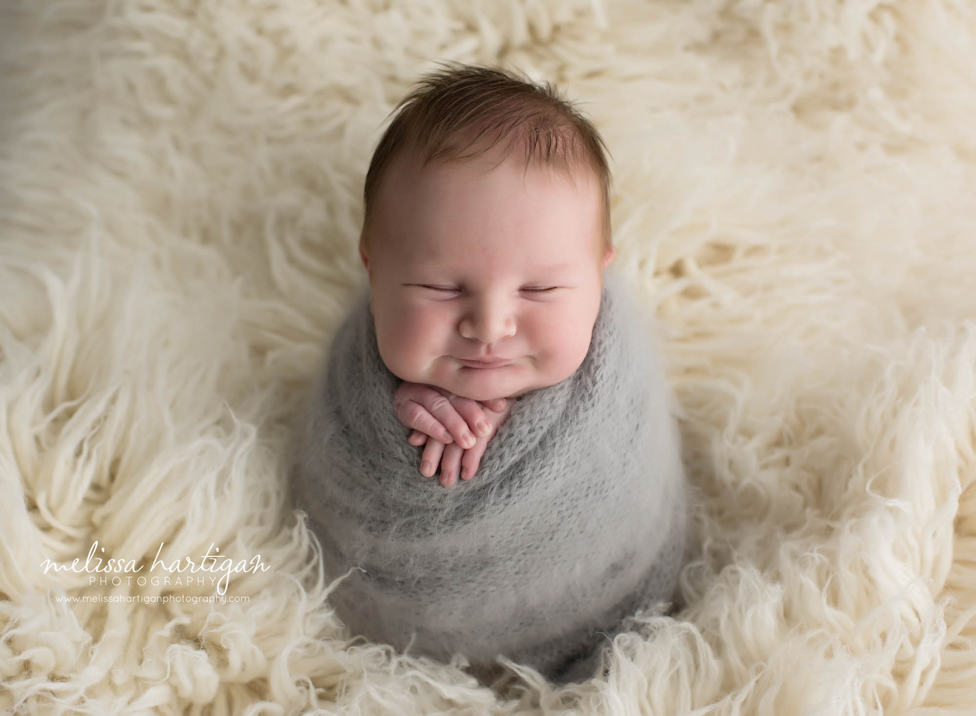 newborn baby boy wrapped in gray potato sack pose newborn photography studio session in connecticut